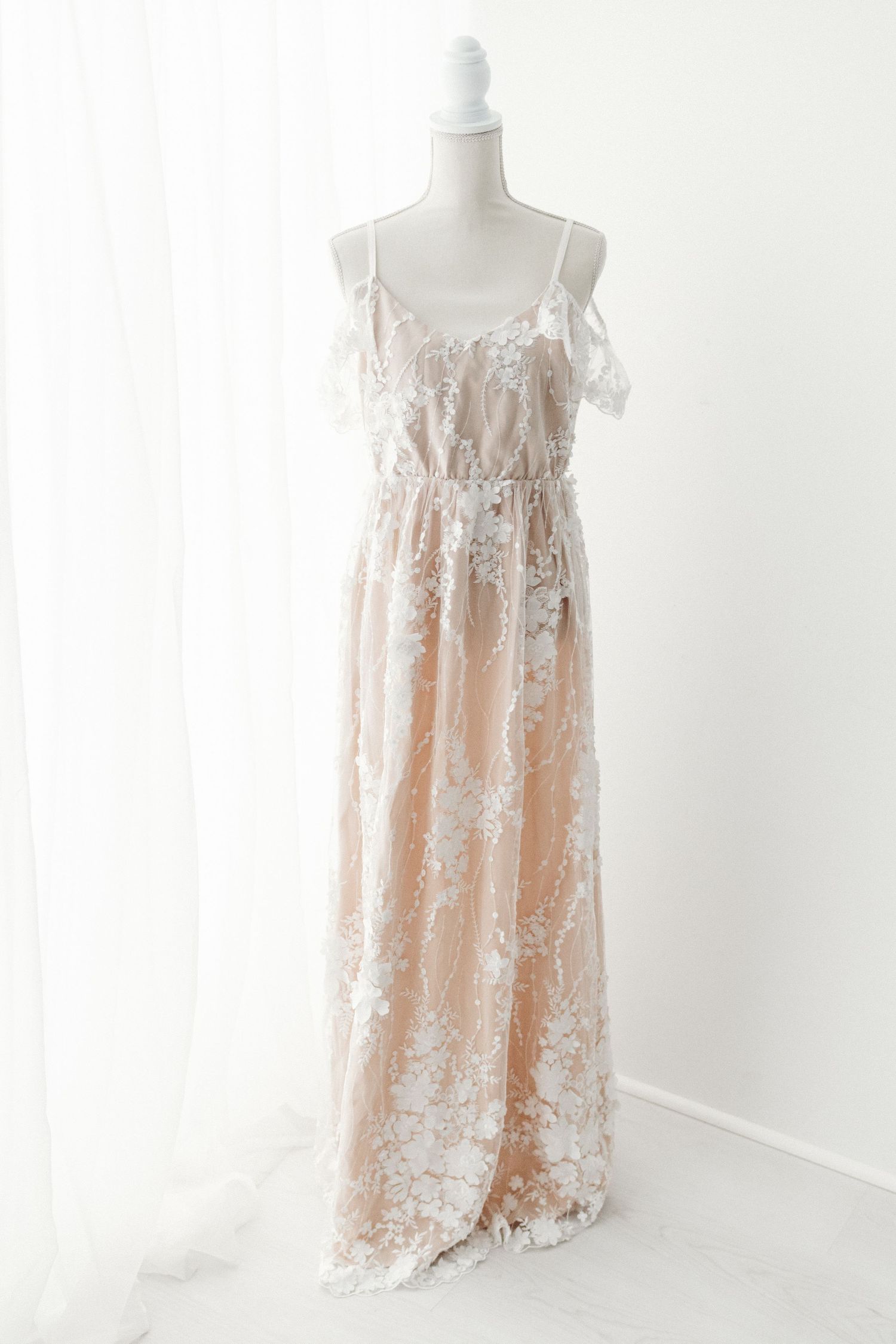 Blush floral lace maxi dress with spaghetti straps and off-shoulder ruffle detail.
