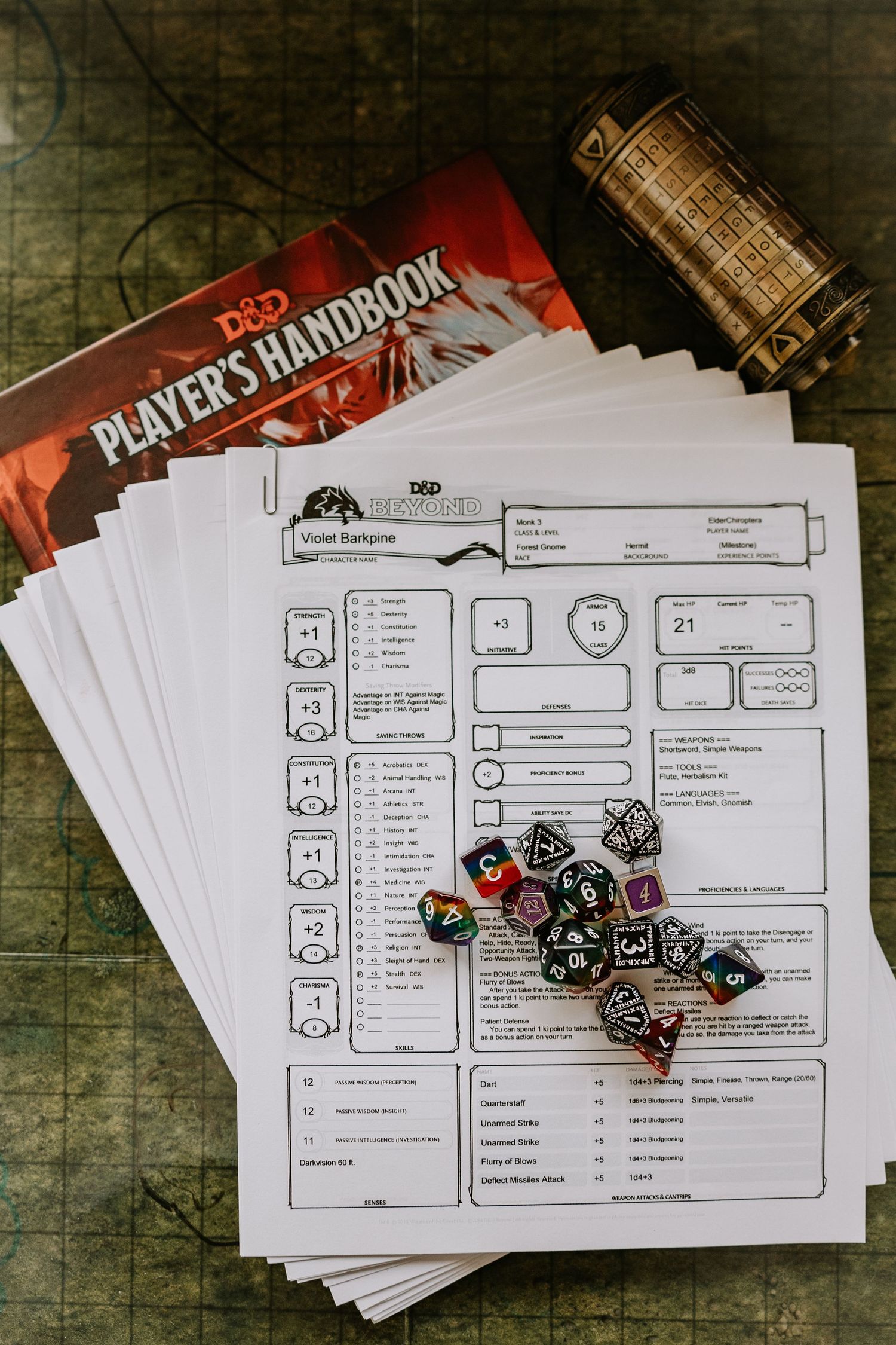 player character sheets on top of a Players Handbook with puzzle cylinder nearby