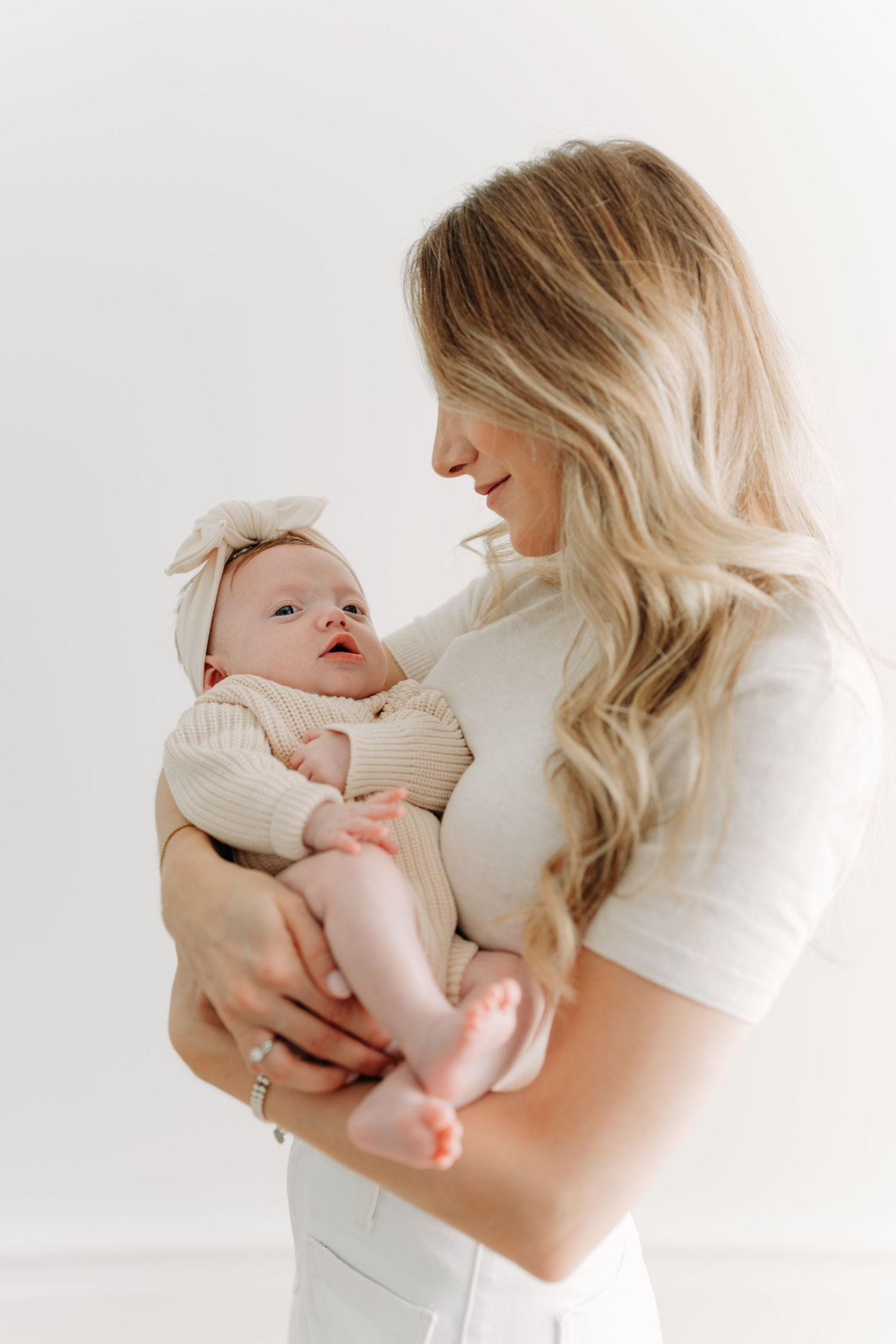 Tendre moment entre une maman et son ravissanr nouveau-né pour une séance nouveau-né fine art au studio de Québec
