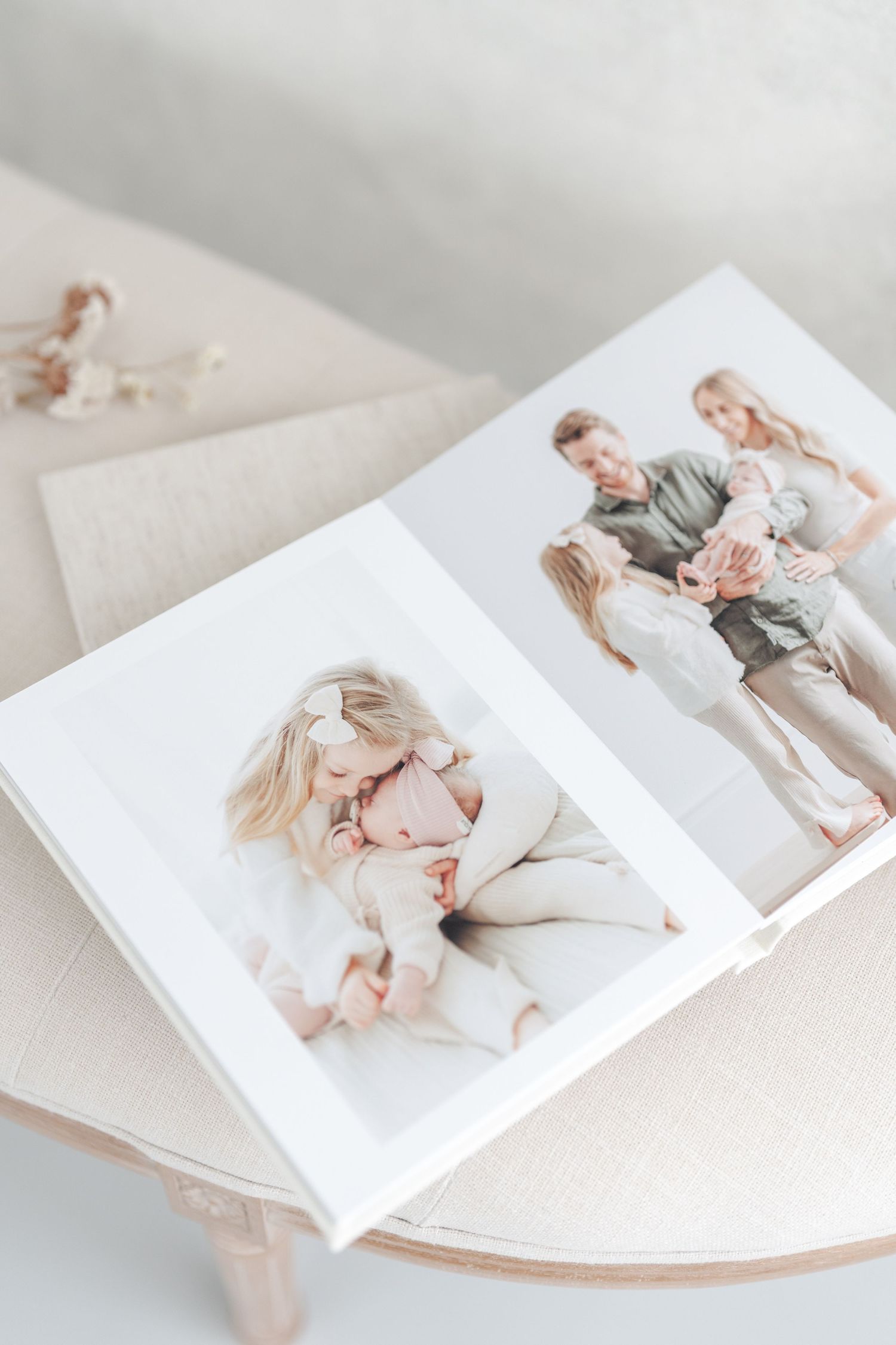 Album fine art giclée format 8x10 ouvert montrant une séance photo de nouveau-né en famille au studio de Saint-Augustin-de-Desmaures