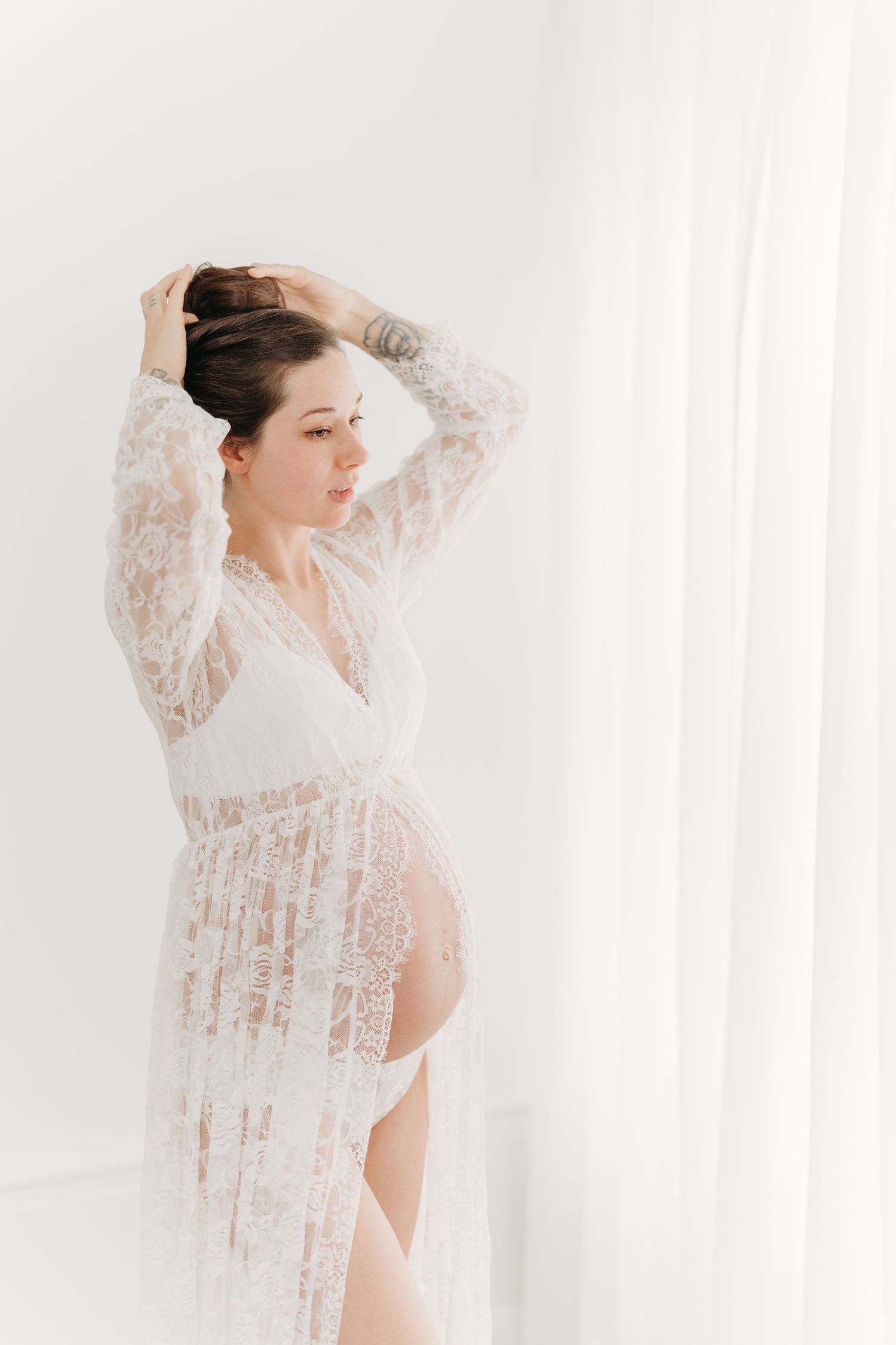 Future maman dans une robe de dentelle délicate laissant voir son ventre arrondi