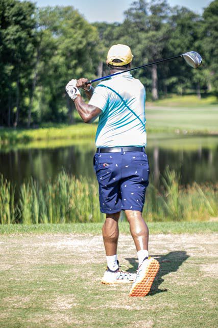A sequence of golf swing follow-through shots showing proper form on a sunny course near a lake.