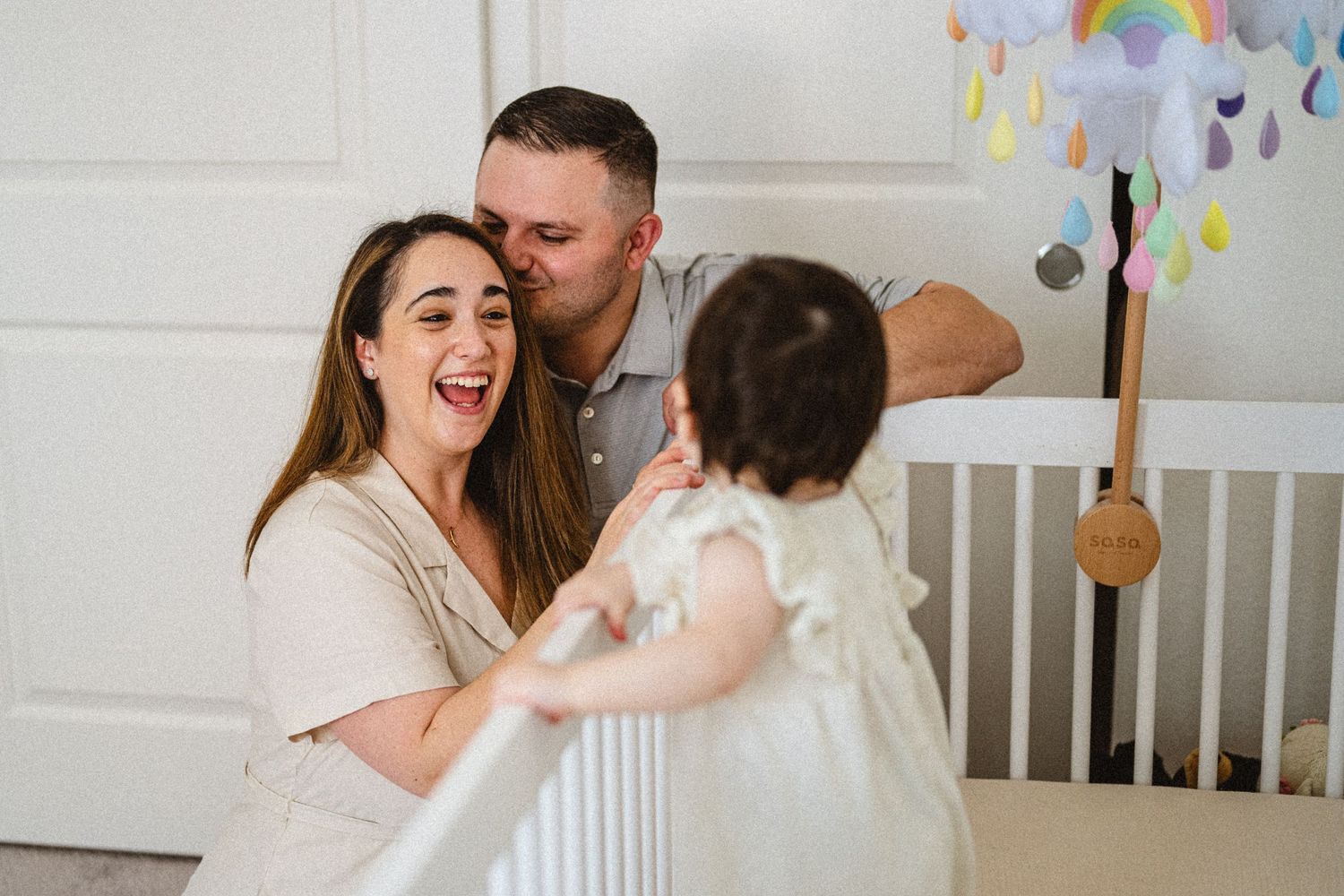 Family sharing a joyful moment together in a nursery with festive decorations.
