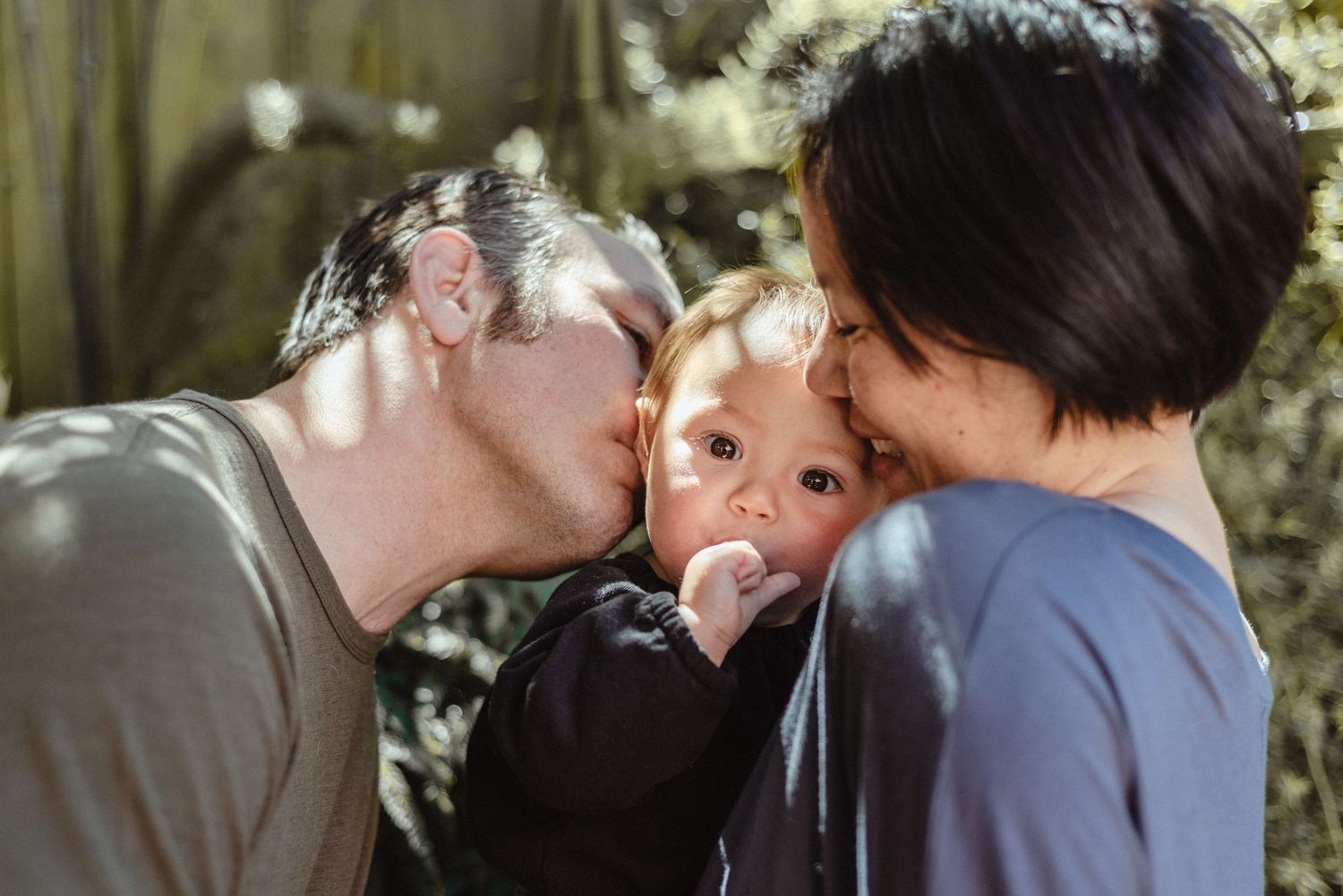 An intimate family moment shared outdoors in natural lighting.