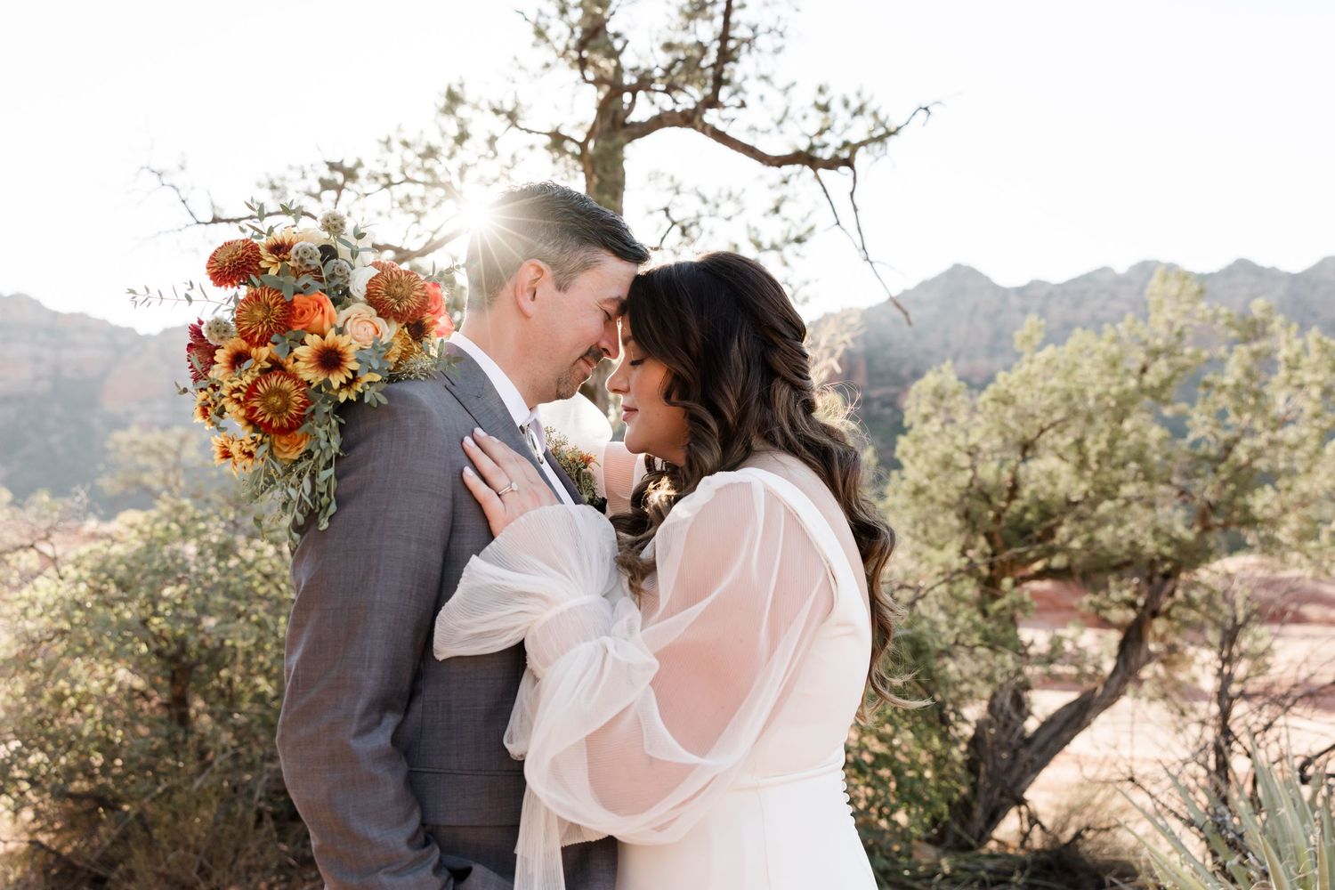 Romantic wedding portraits with mountain scenery and autumn-colored floral bouquet.