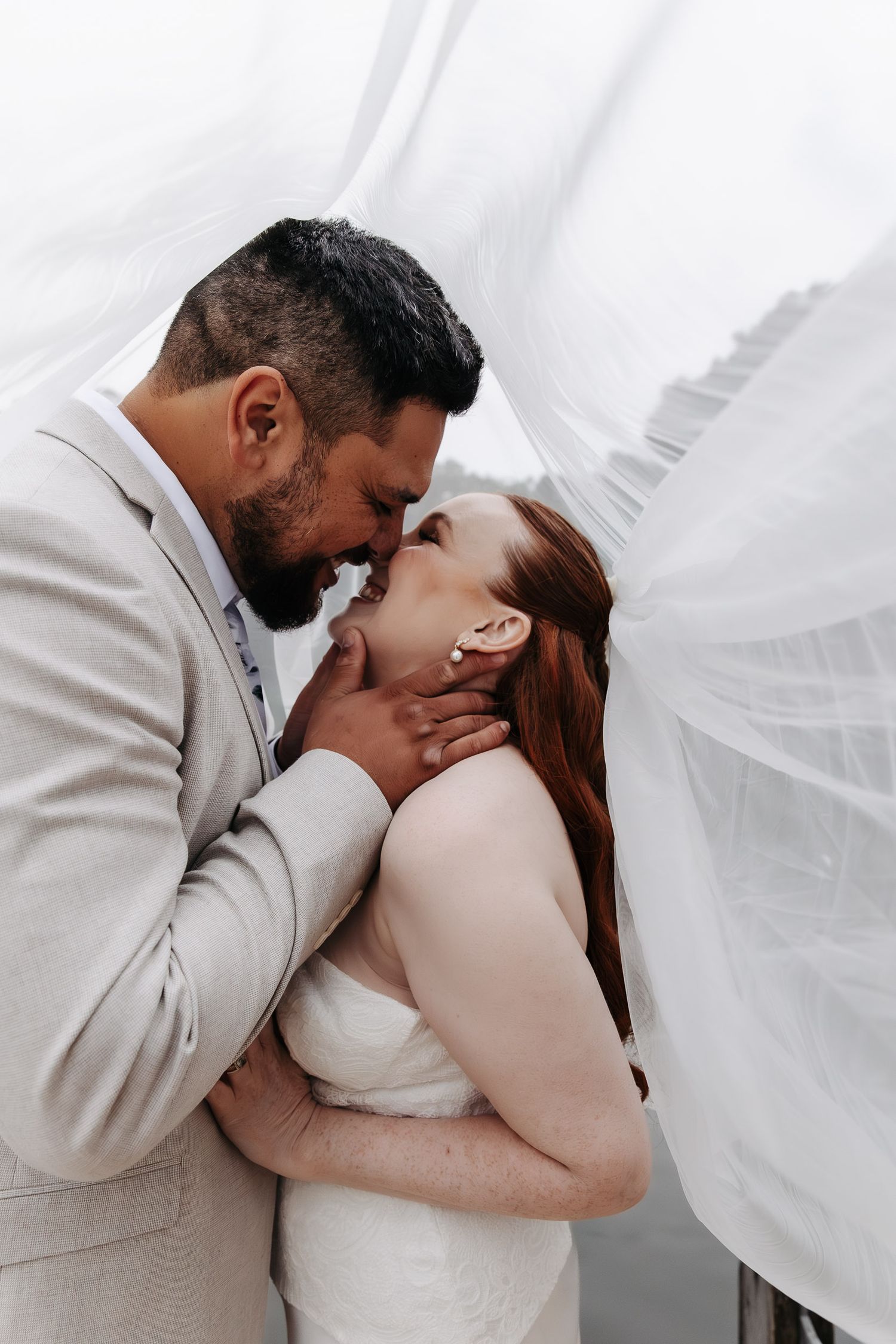 A romantic wedding couple shares intimate kisses behind flowing white veils in a series of tender moments.