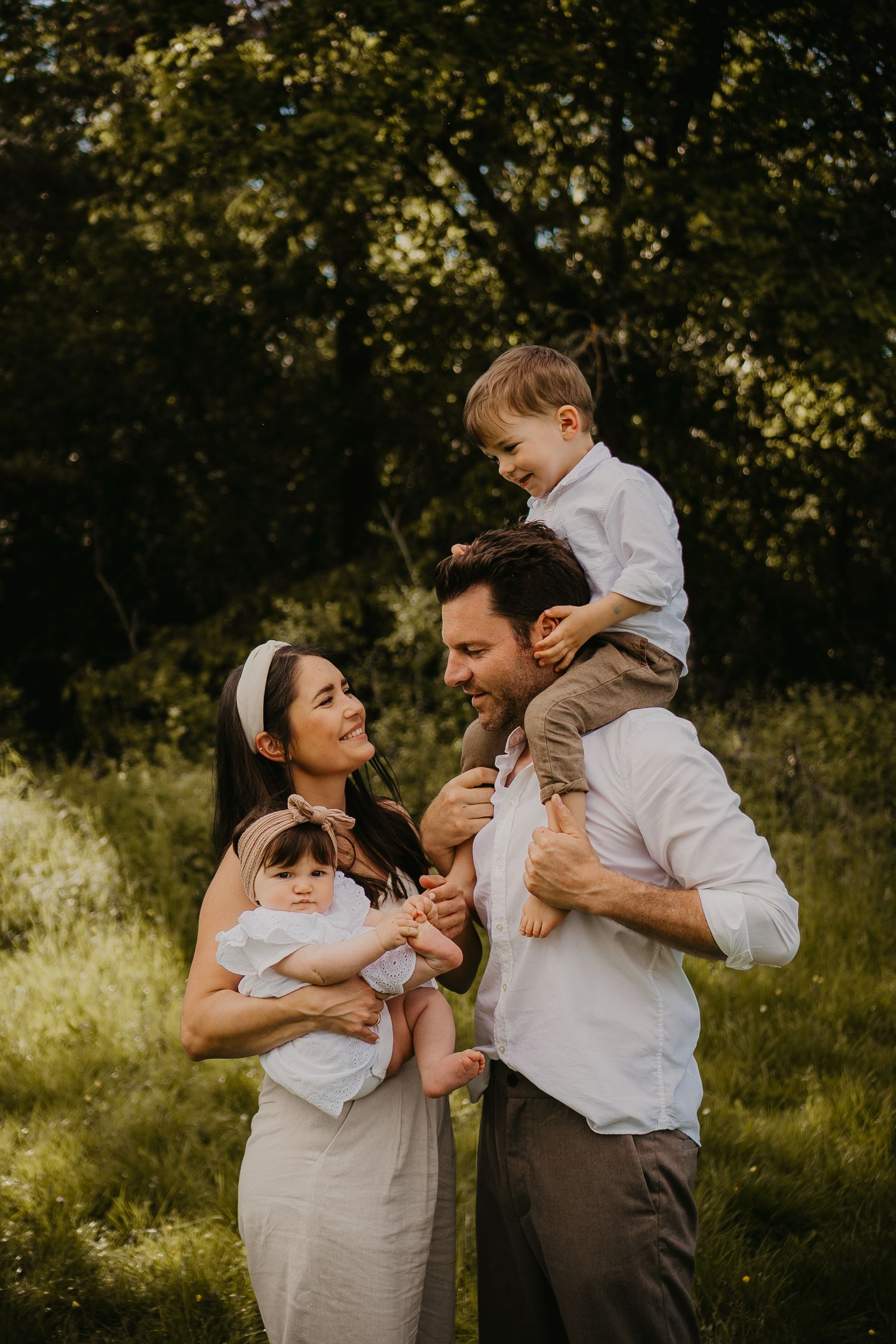A family spending time together outdoors in a sunlit garden setting during a warm summer day.
