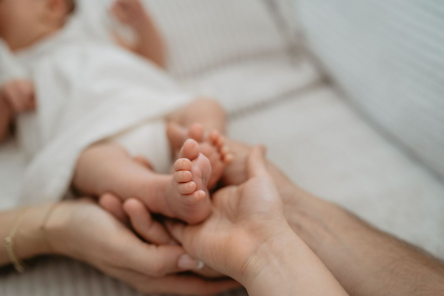 Close up of gentle hands massaging someone's palm and fingers on a white table during a relaxing massage therapy treatment.