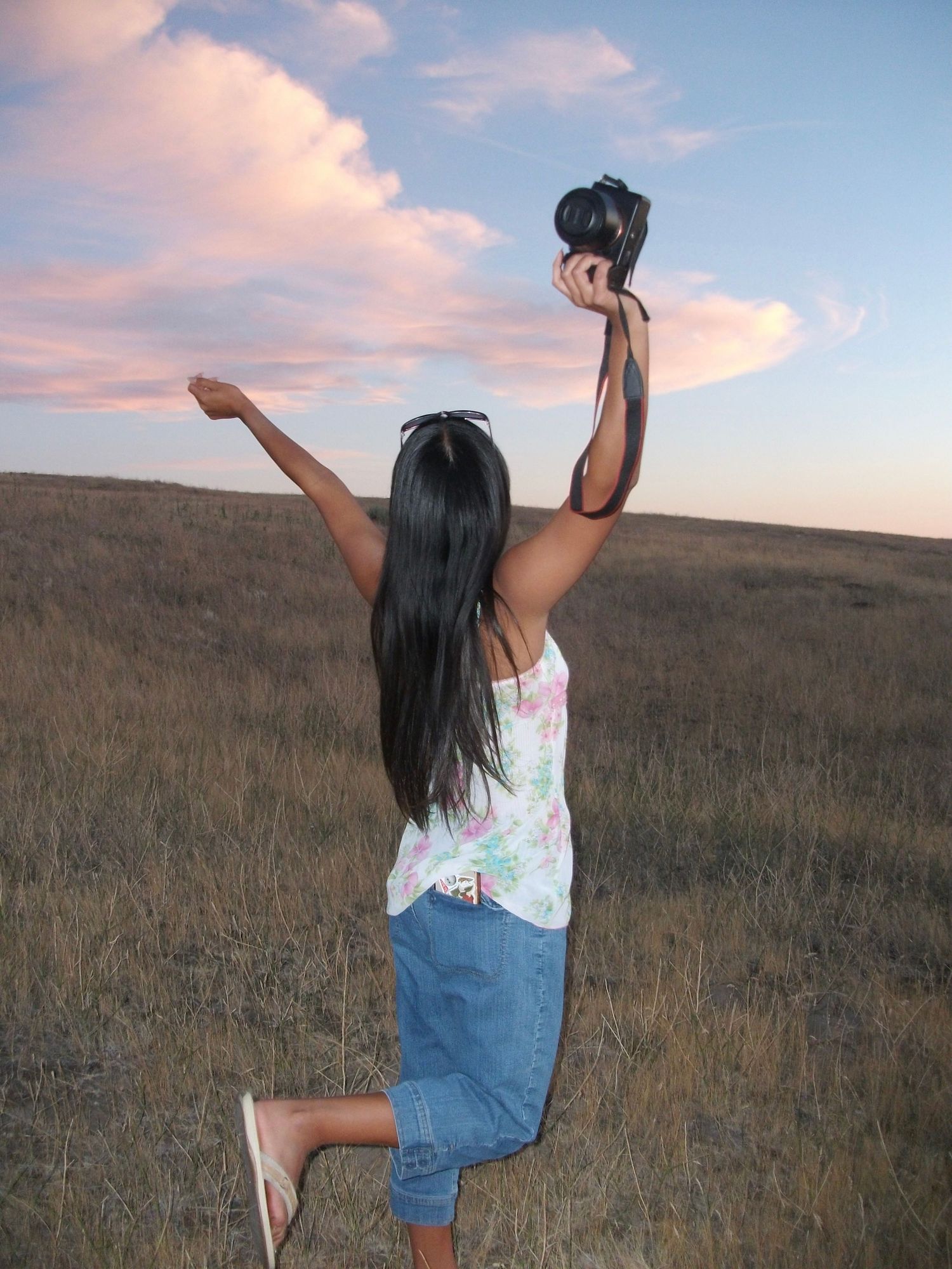 Anna holding camera in the sunset.