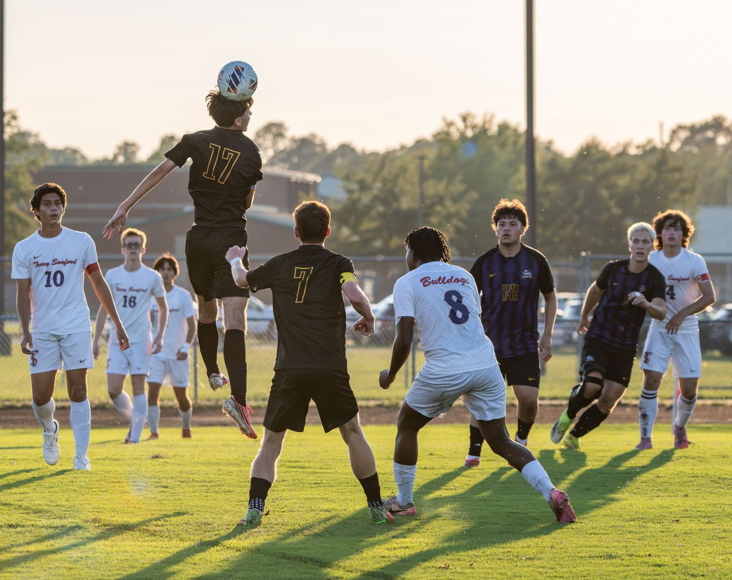 High school boys soccer players competing for the ball during a game
