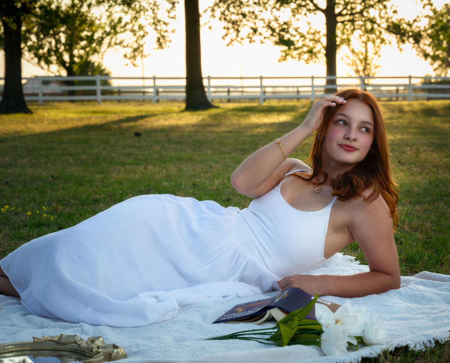 Outdoor portrait of a young woman in a white dress at sunset