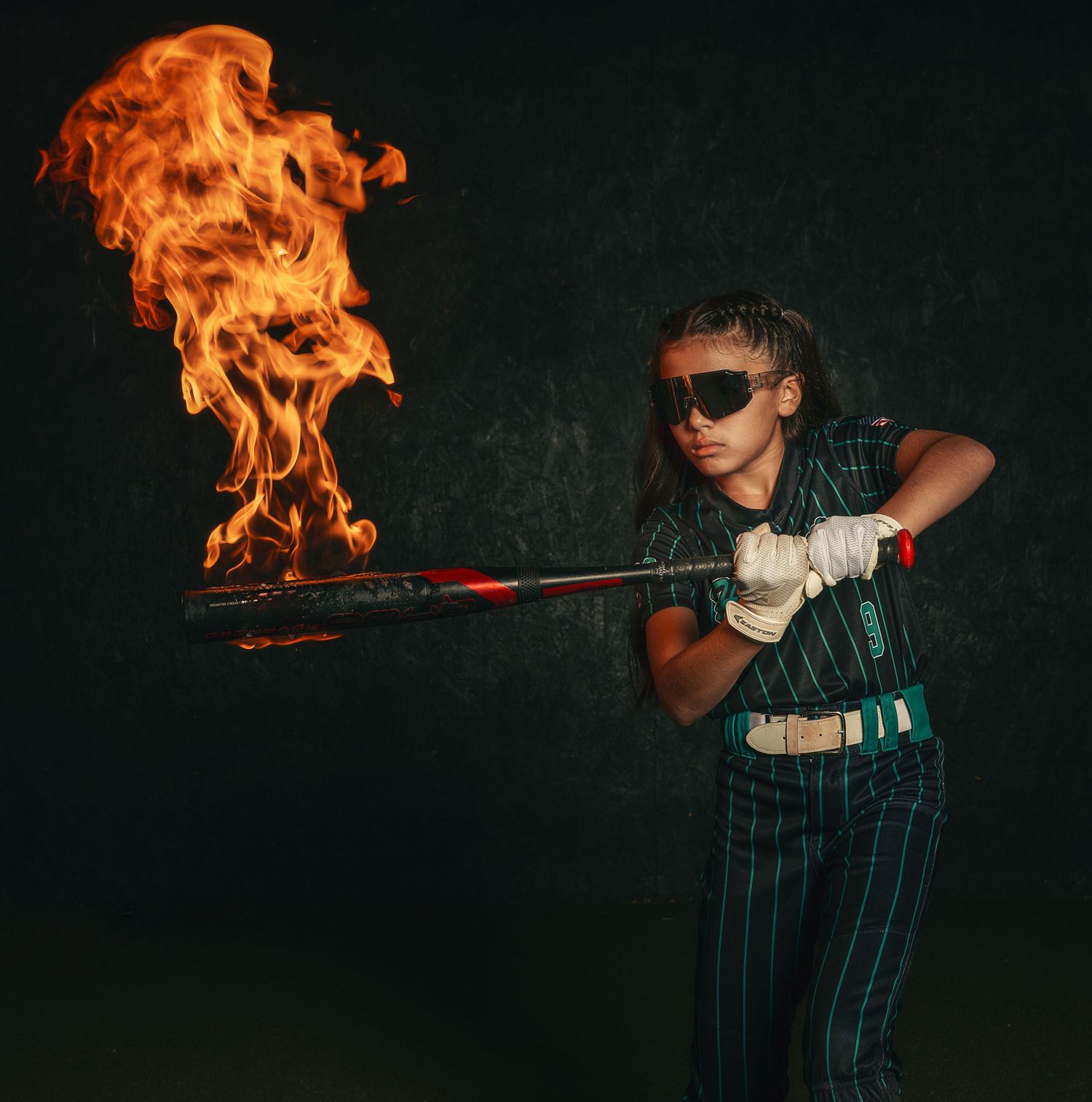 Creative softball media day portrait featuring a controlled fire effect