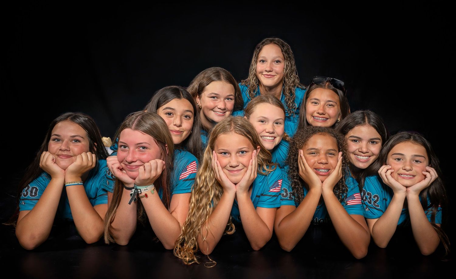 Softball team media day group portrait against a dark background