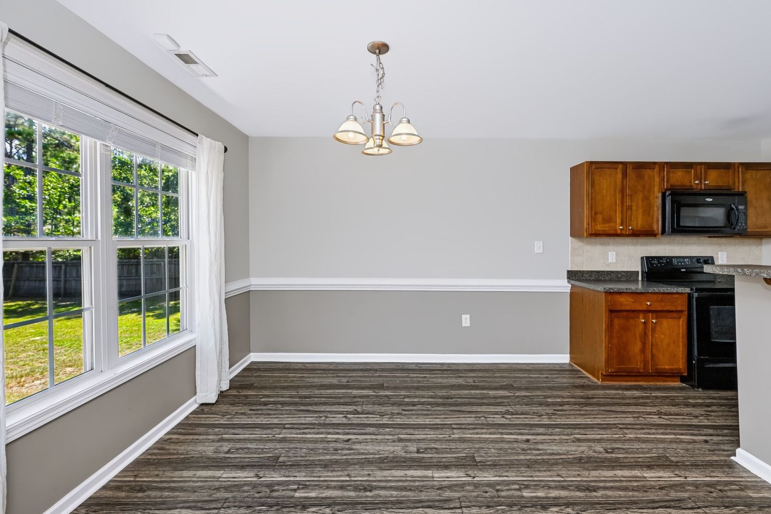 Real estate photograph of an open dining area and kitchen