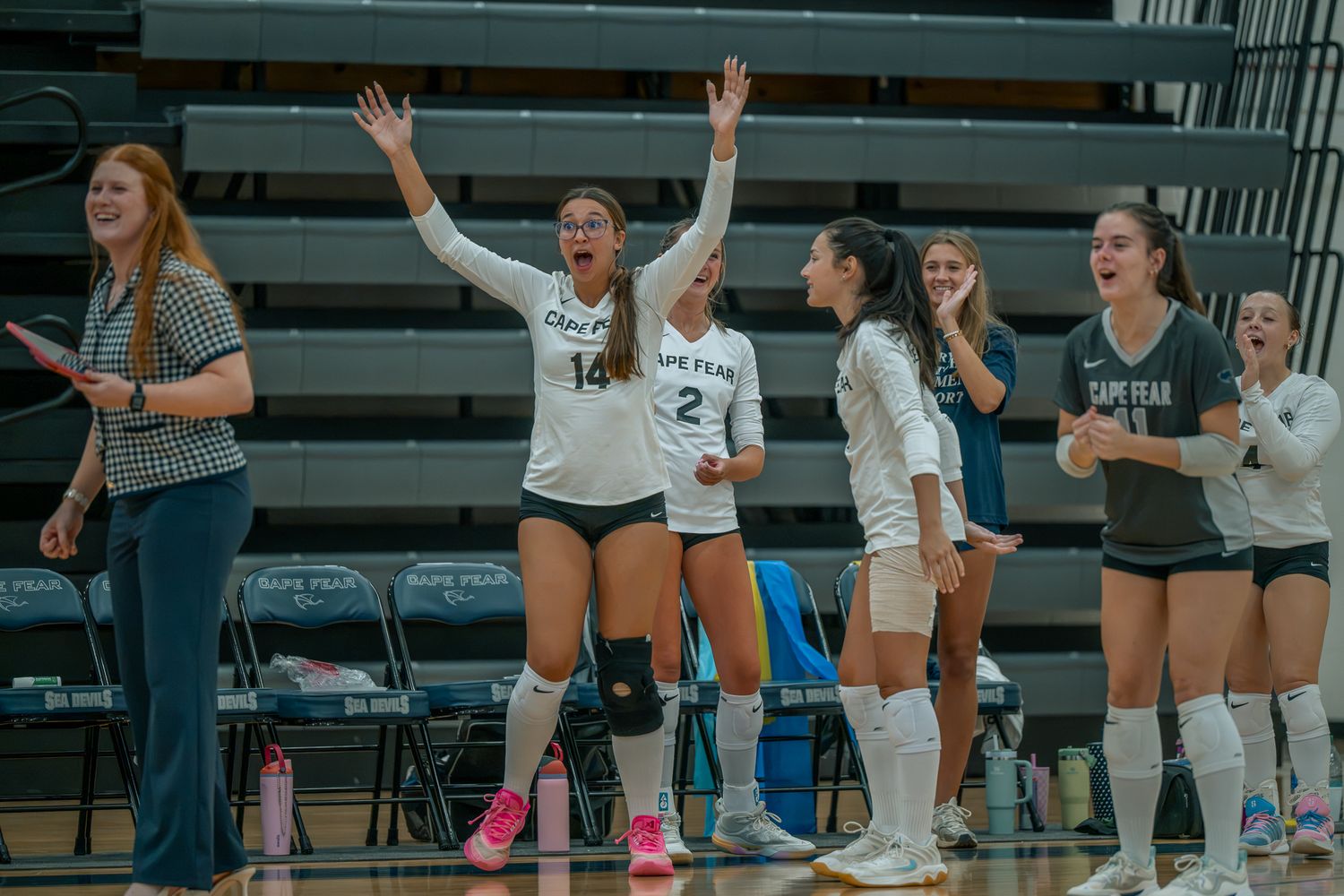High school volleyball team celebrating from the sideline