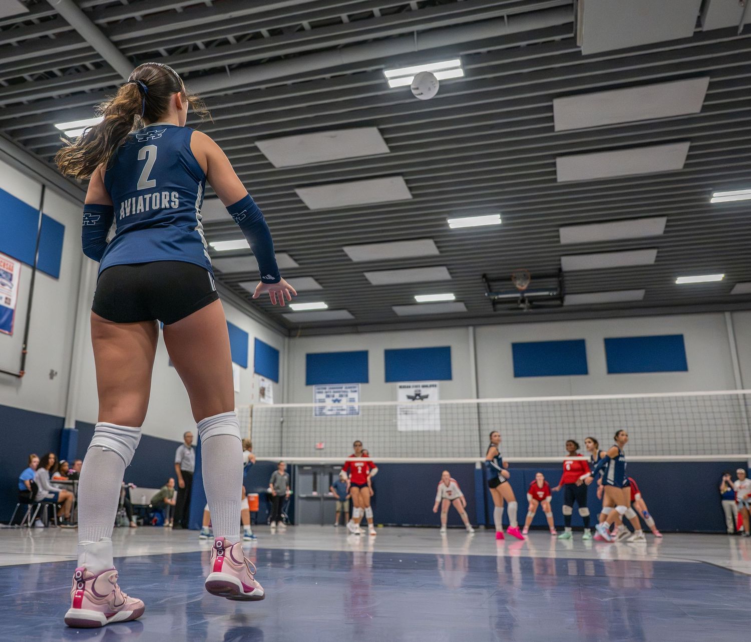 Low-angle high school volleyball action photograph during a match