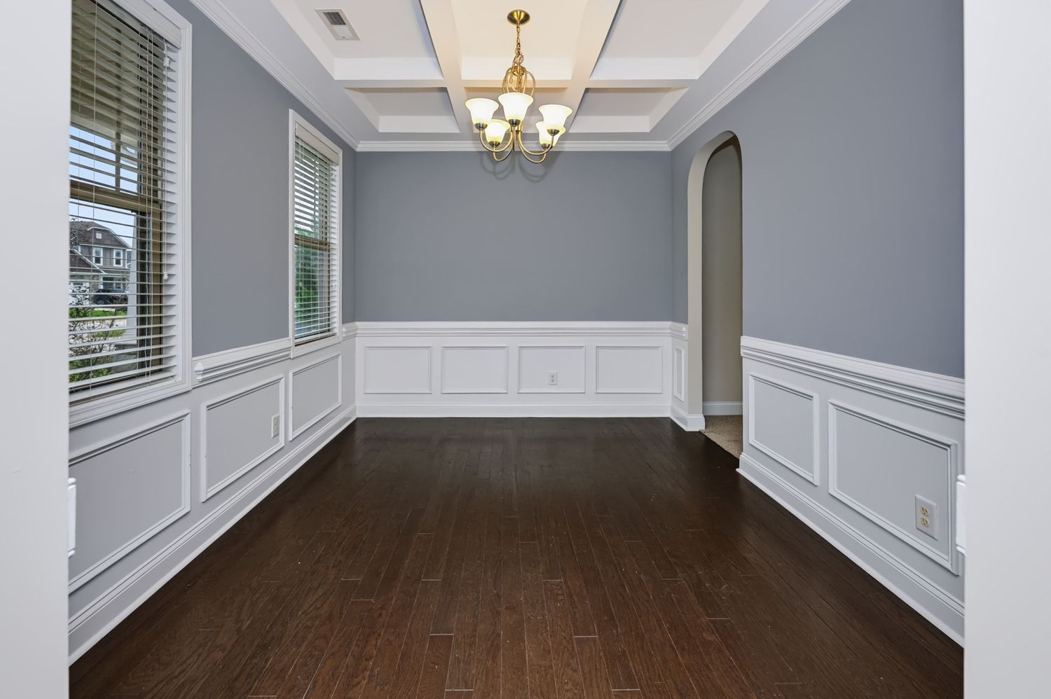Real estate photograph of an empty dining room with hardwood floors