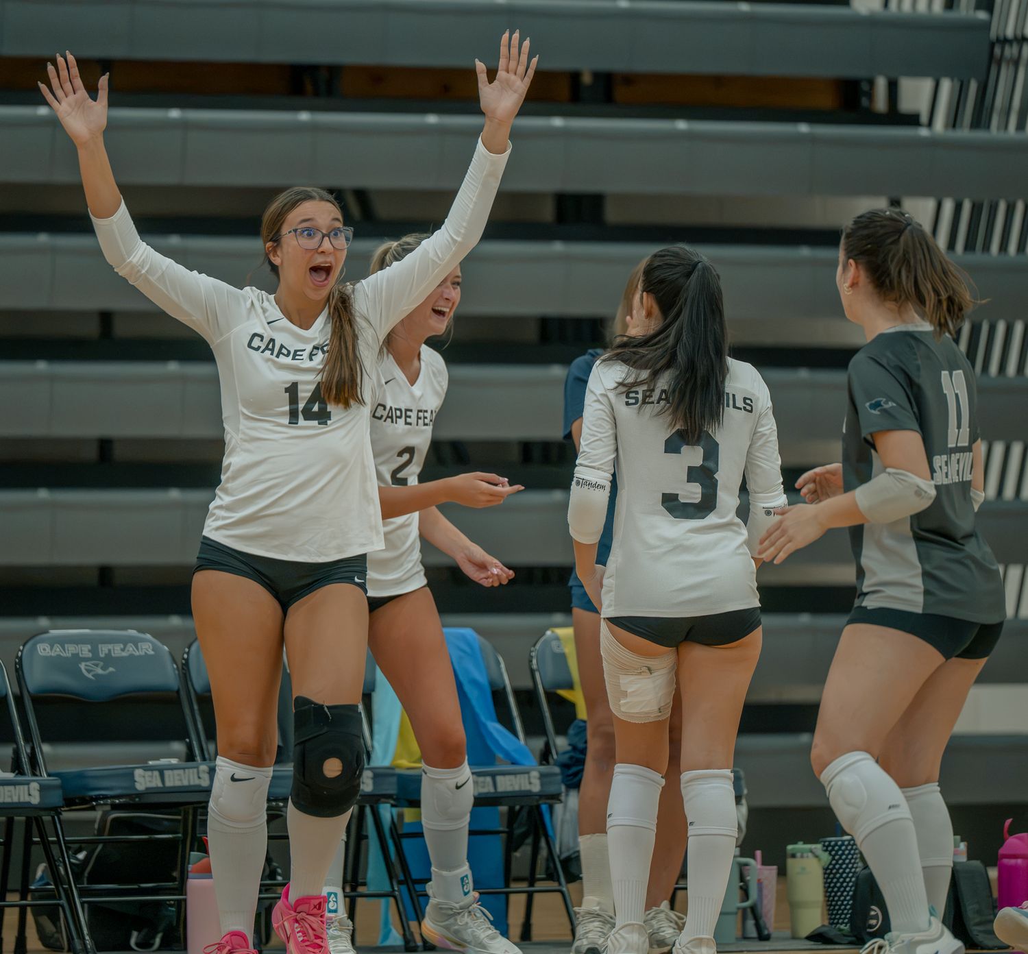 High school volleyball players celebrating together during a match