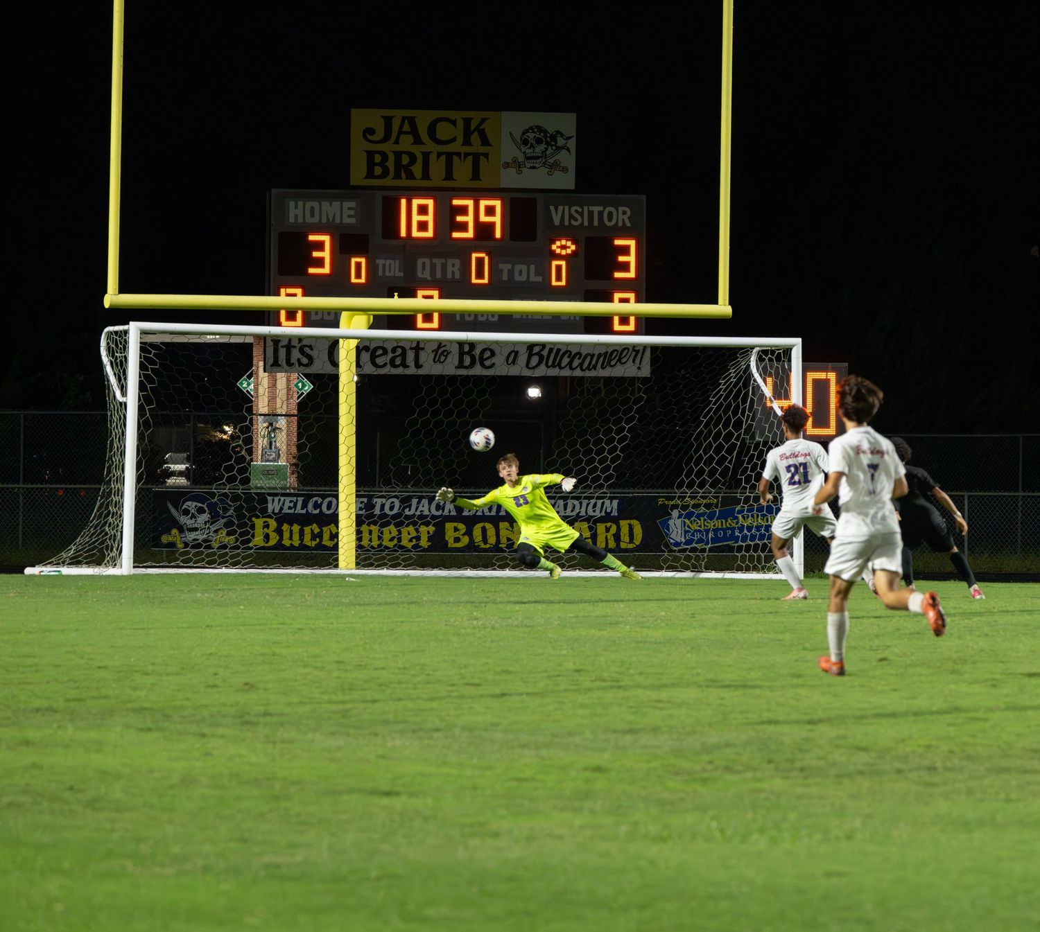 High school soccer action photographed under stadium lights