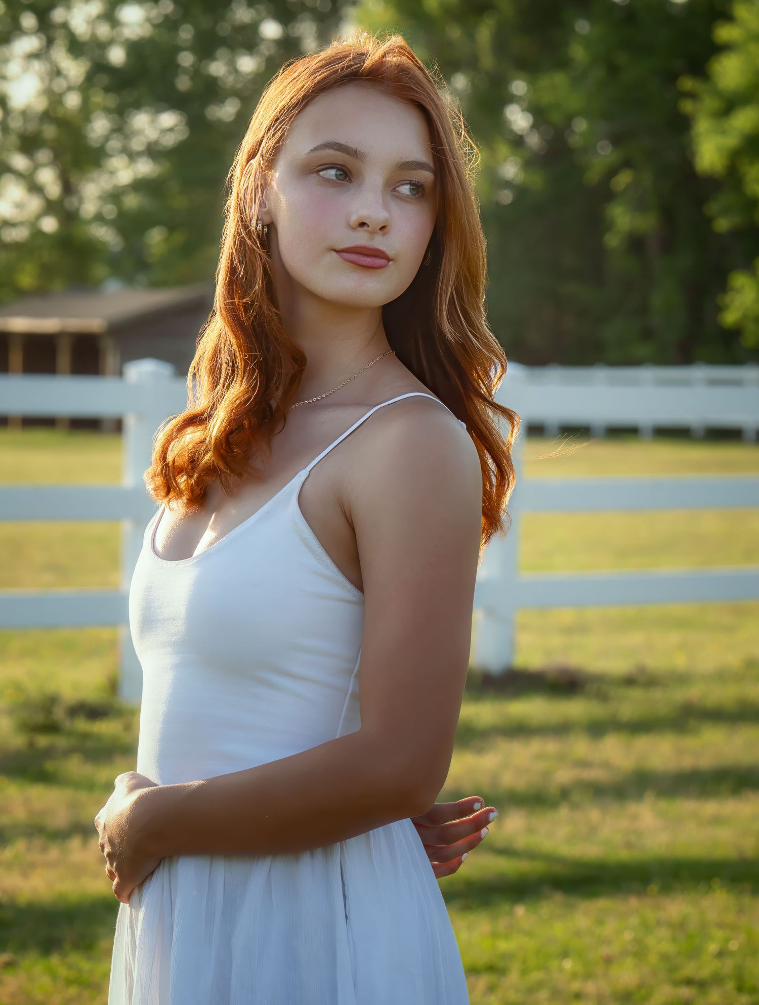 Outdoor senior portrait in a white dress during golden hour