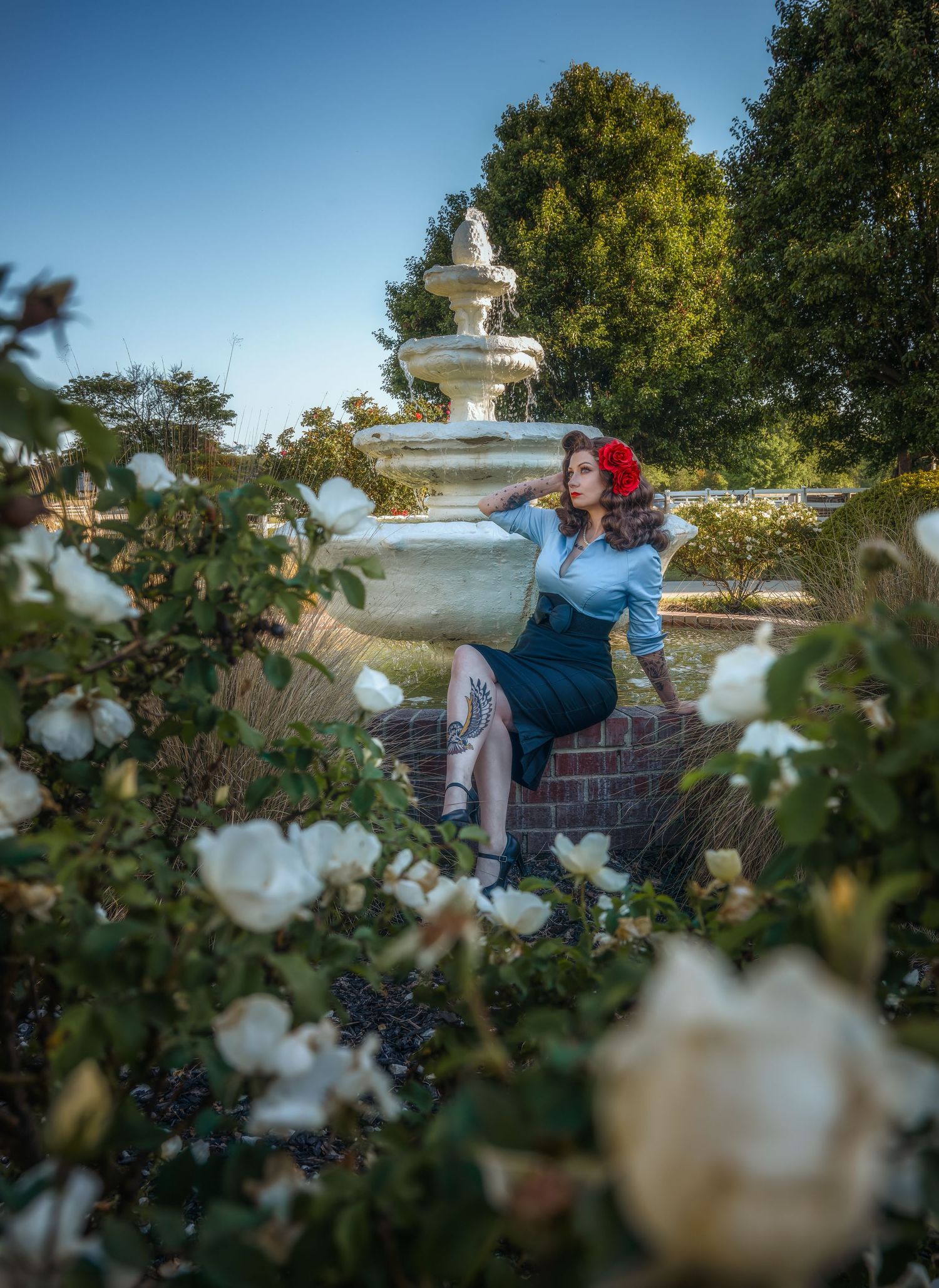 Creative portrait in an emerald green formal gown beneath trees