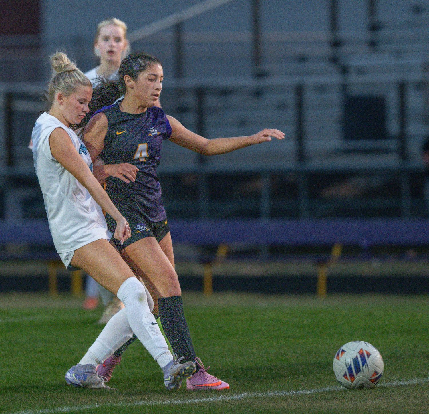 High school girls soccer players competing for the ball during a game