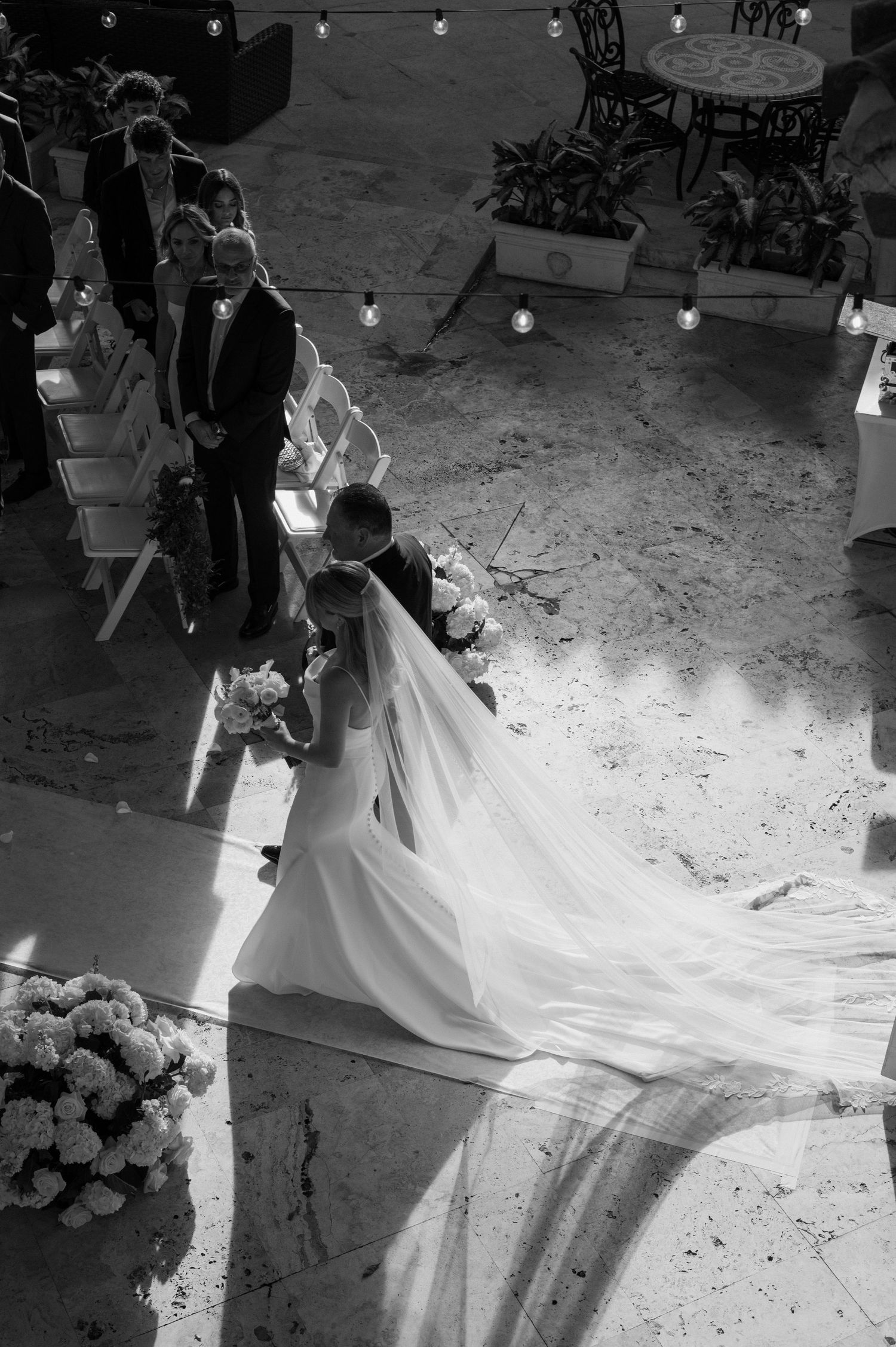 Over the balcony photo of the bride walking down the aisle with her father