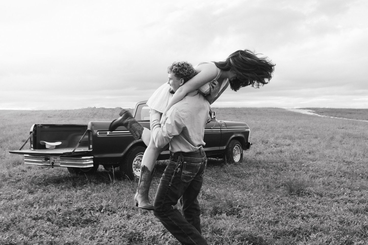 Couple being playful in field during engagement photo session