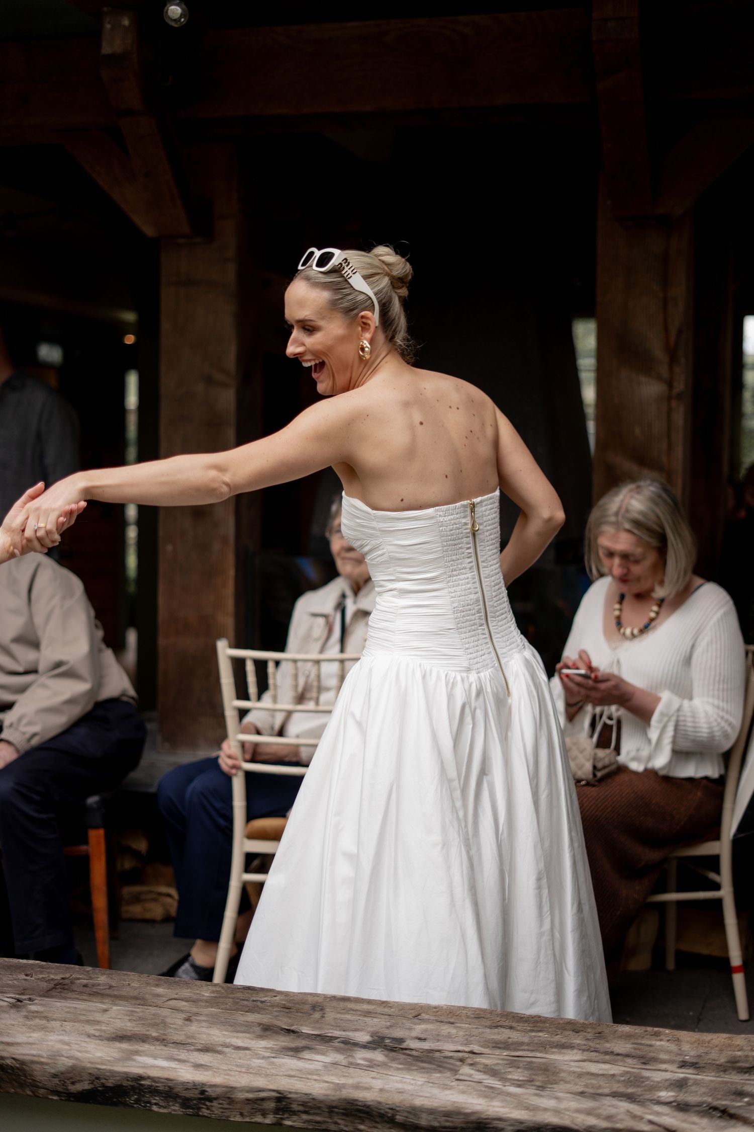 The bride being pulled into dance at a wedding
