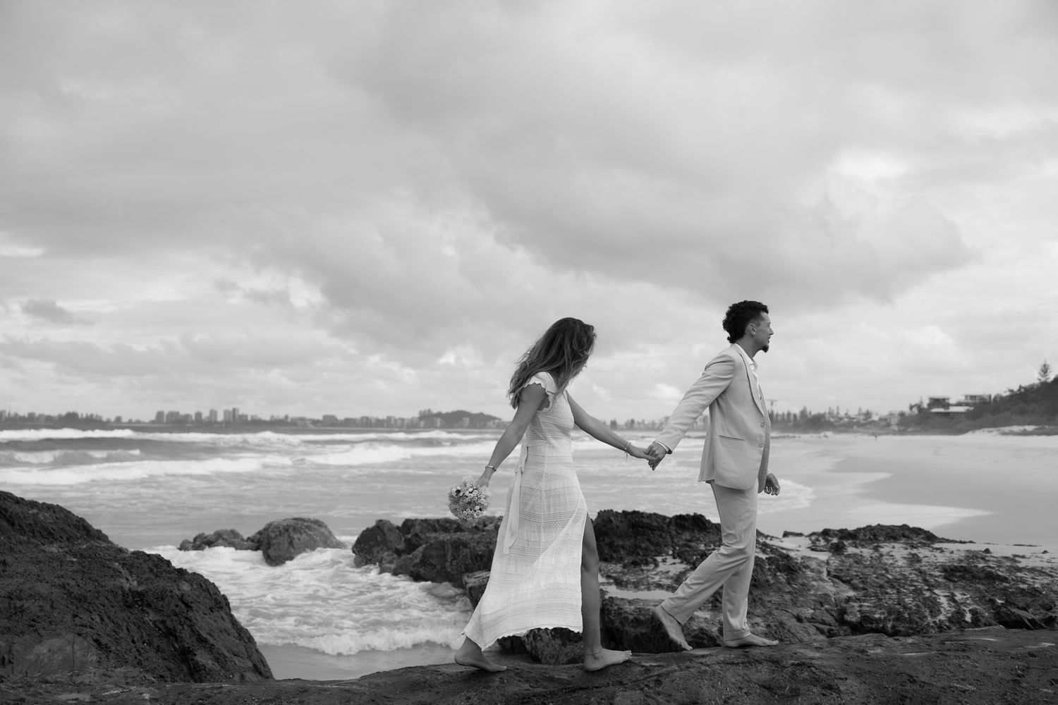 Groom leading bride across beach after getting eloped on the Gold Coast