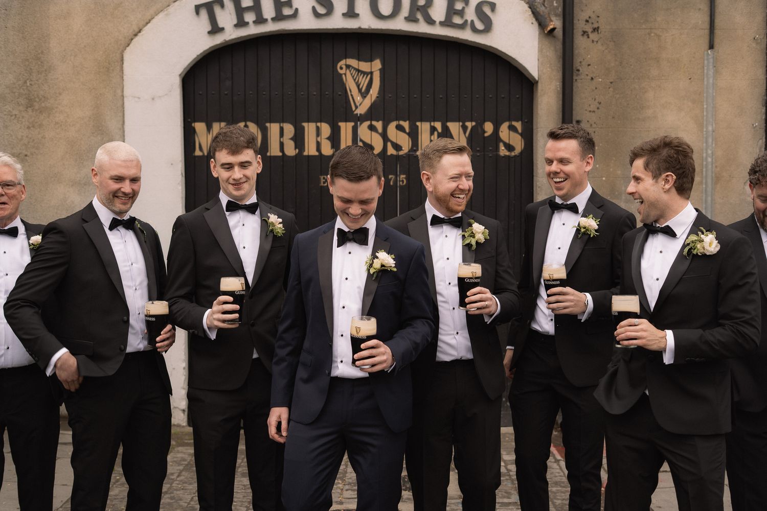 The groom and groomsmen laughing together with a beer before a Brisbane wedding