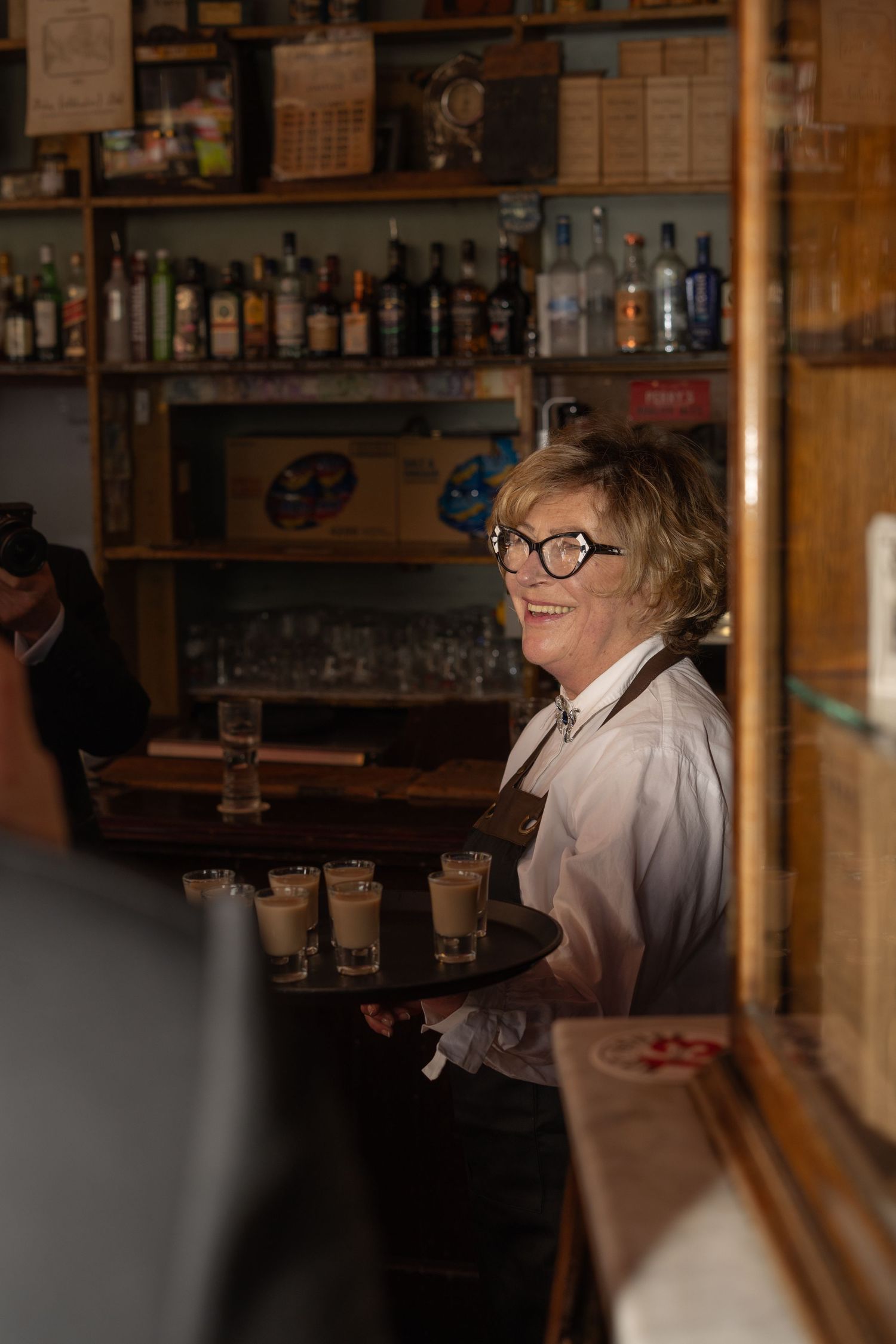 A waitress bringing shots for the groomsmen at a wedding