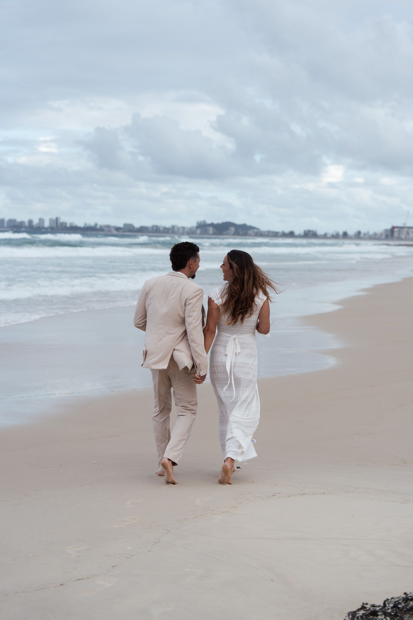 bride and groom walking along beach after getting eloped on the Gold Coast