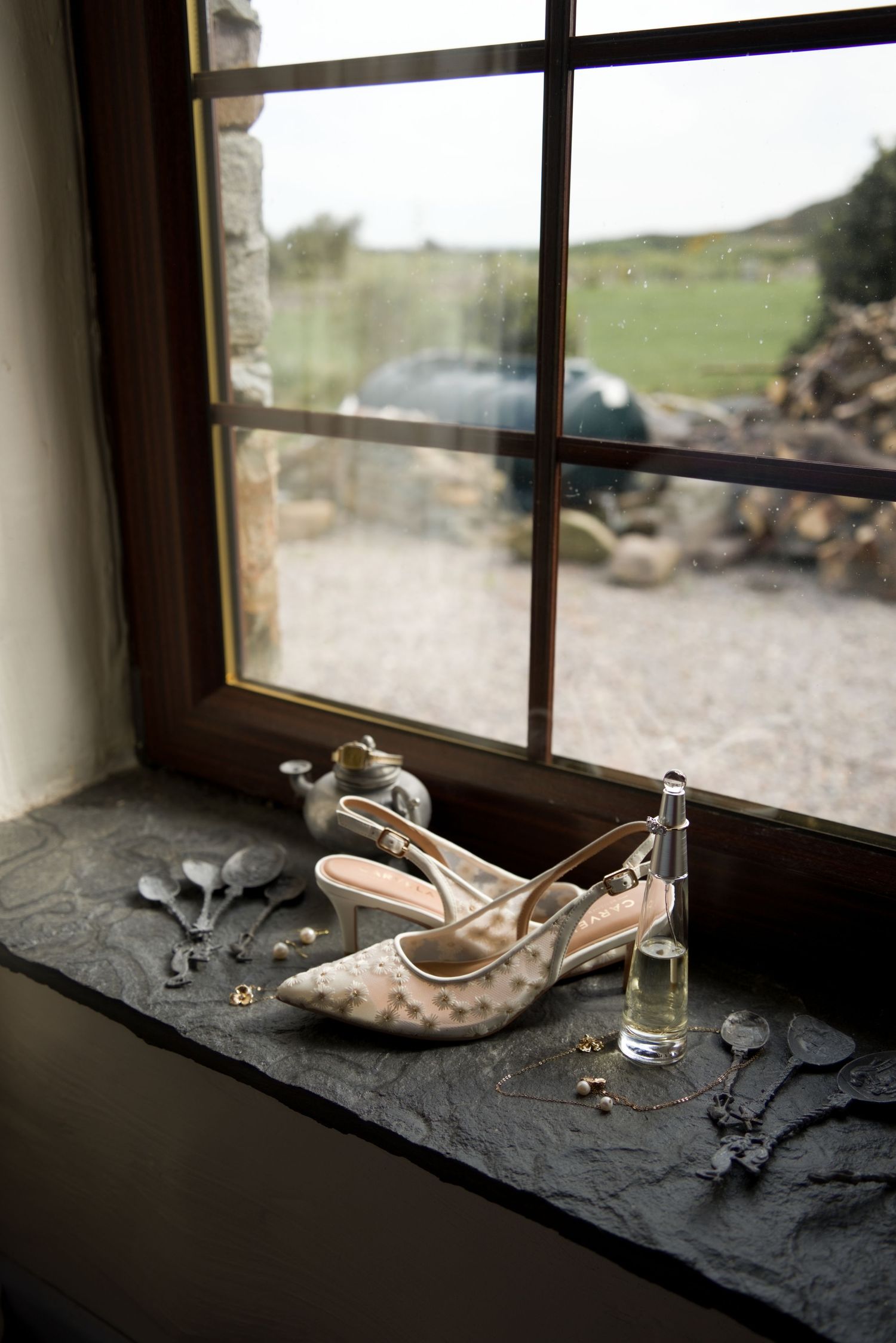 A detail shot of shoes, jewellery and perfume at a scenic rim wedding