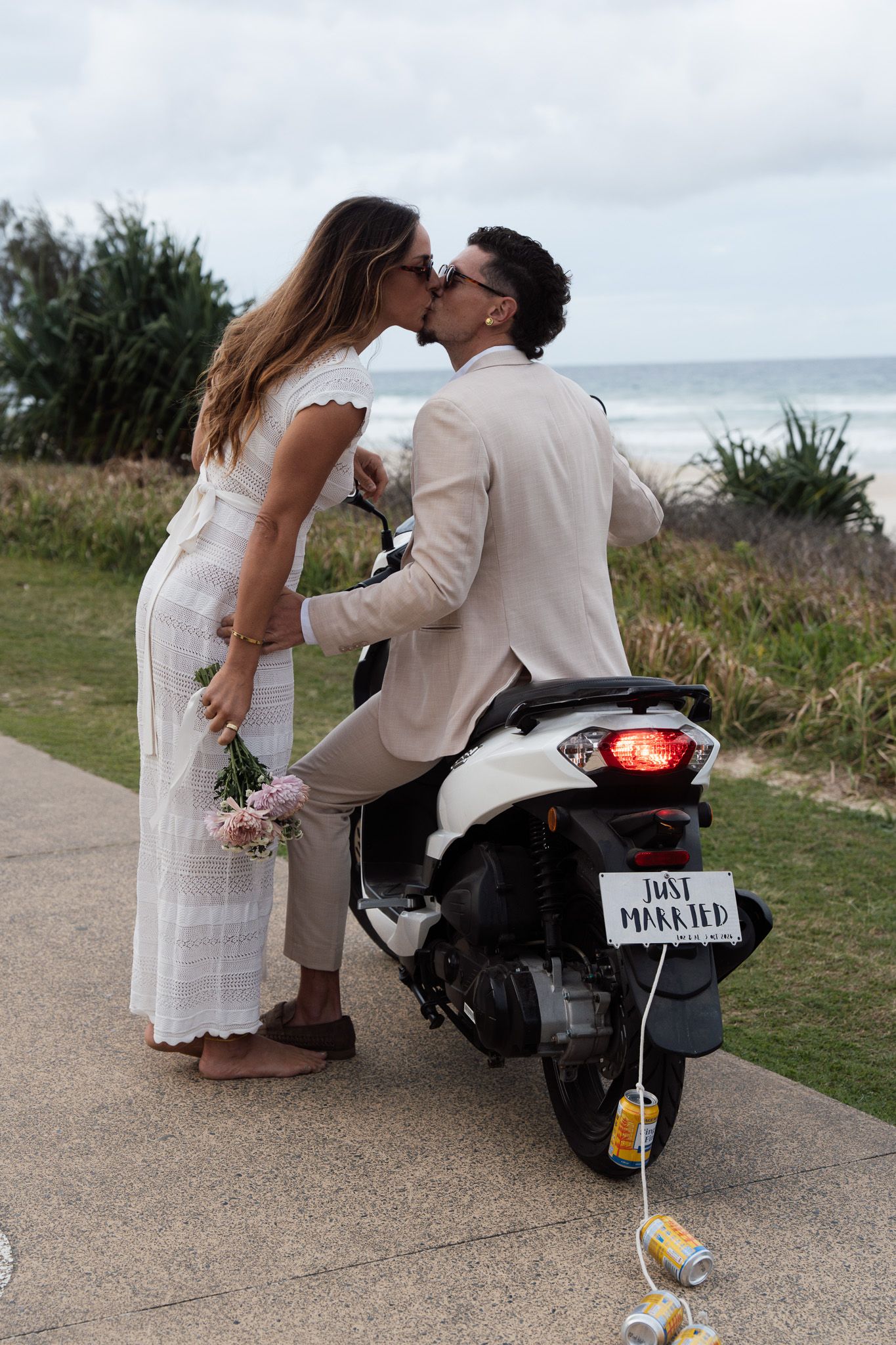 Bride and groom kissing whilst on motorbike after just getting married on the Gold Coast