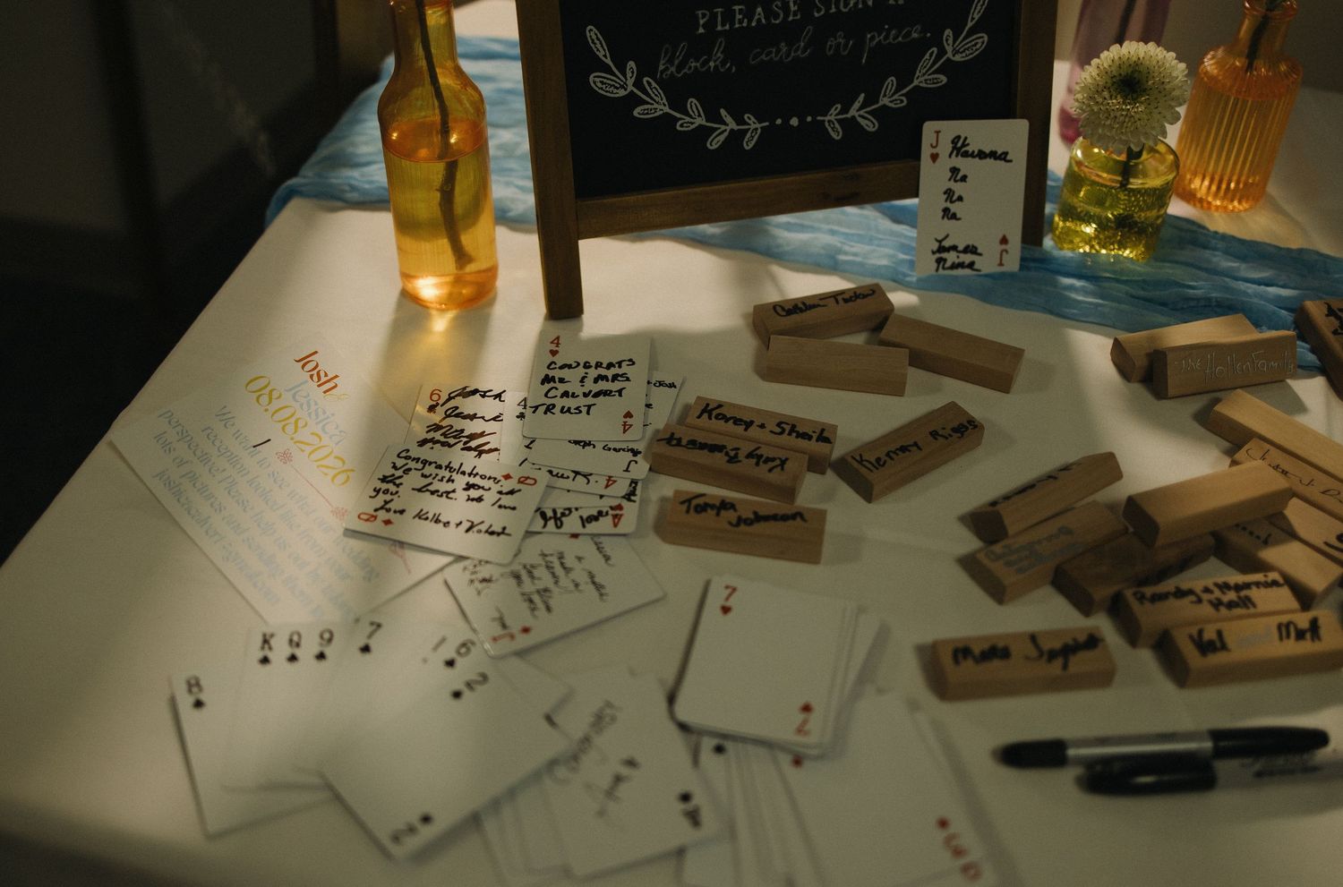 Wedding guest book table with Jenga blocks, cards, and pens for personalized messages.