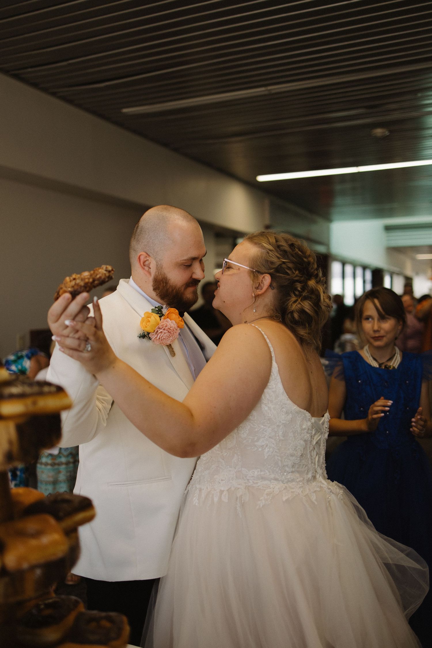 Bride and groom sharing a joyful moment while cutting their wedding cake at the reception.