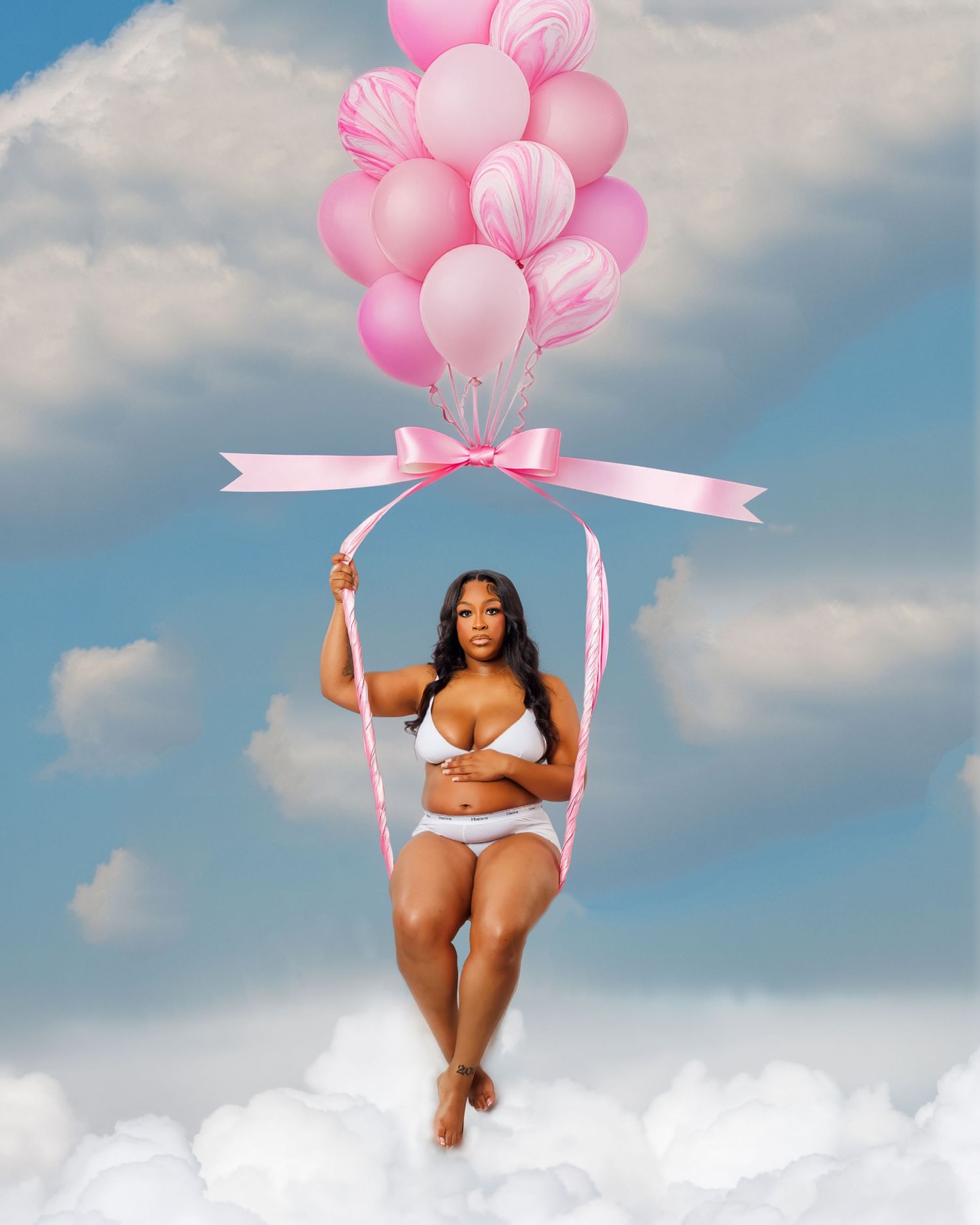 A pregnant woman in white lingerie sits on a swing held by pink balloons among clouds.