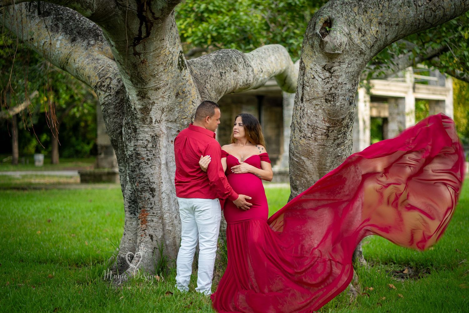 Artistic outdoor photography with flowing red fabric among trees.