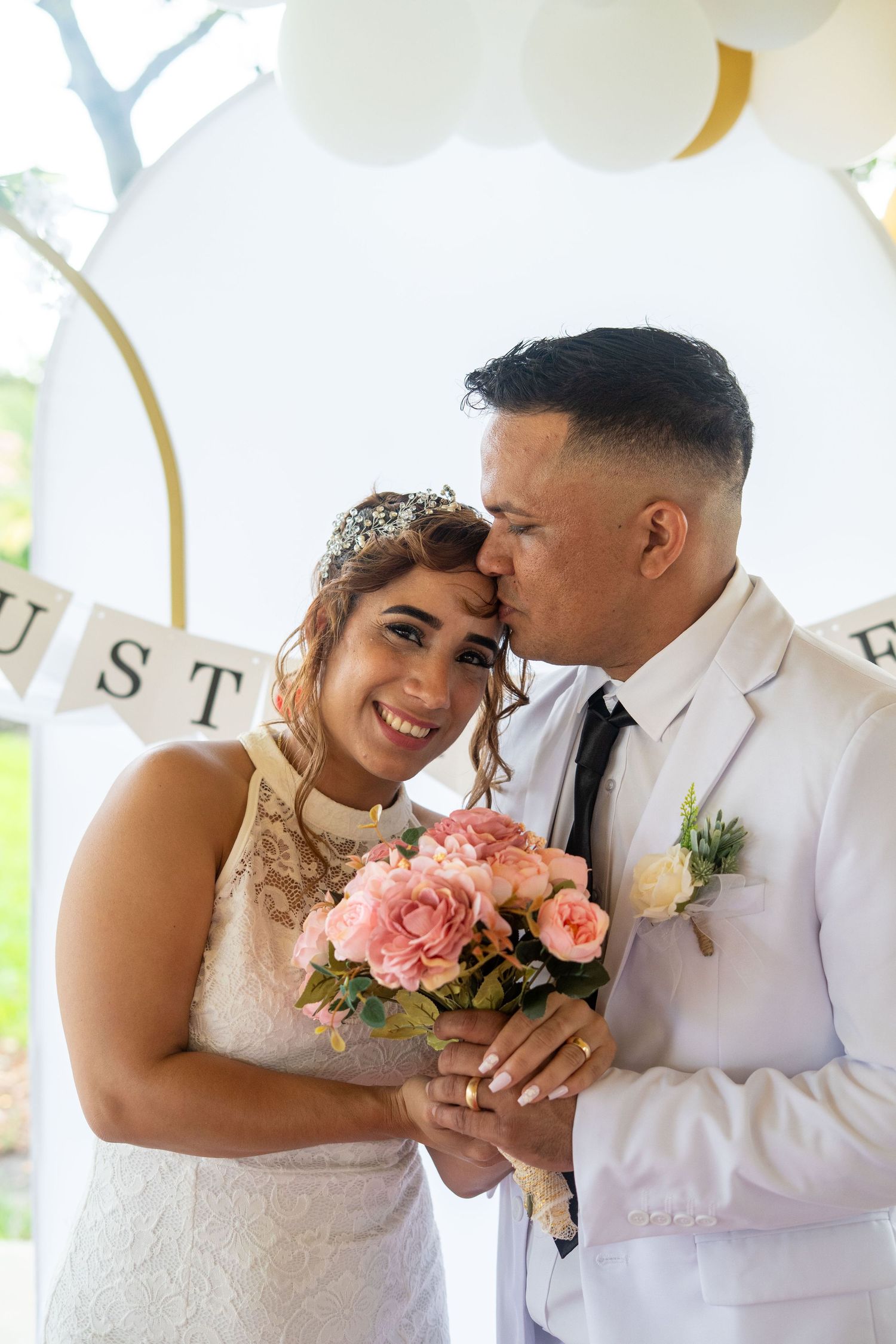 Romantic wedding photoshoot scene with pink roses and elegant white decor.