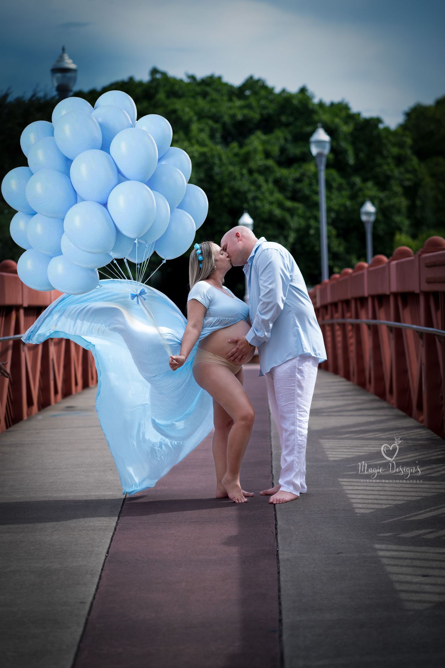 Whimsical boardwalk photoshoot with blue balloons and white dress.