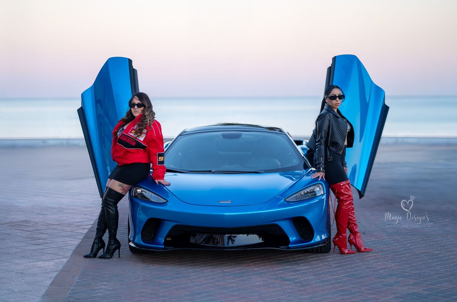 Bright blue sports car photographed at sunset with people standing nearby.
