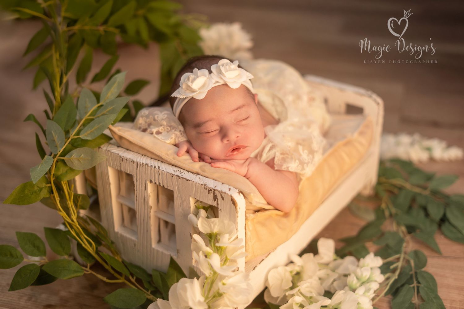 Artistic newborn photo shoot with natural wood tones and soft floral arrangements.