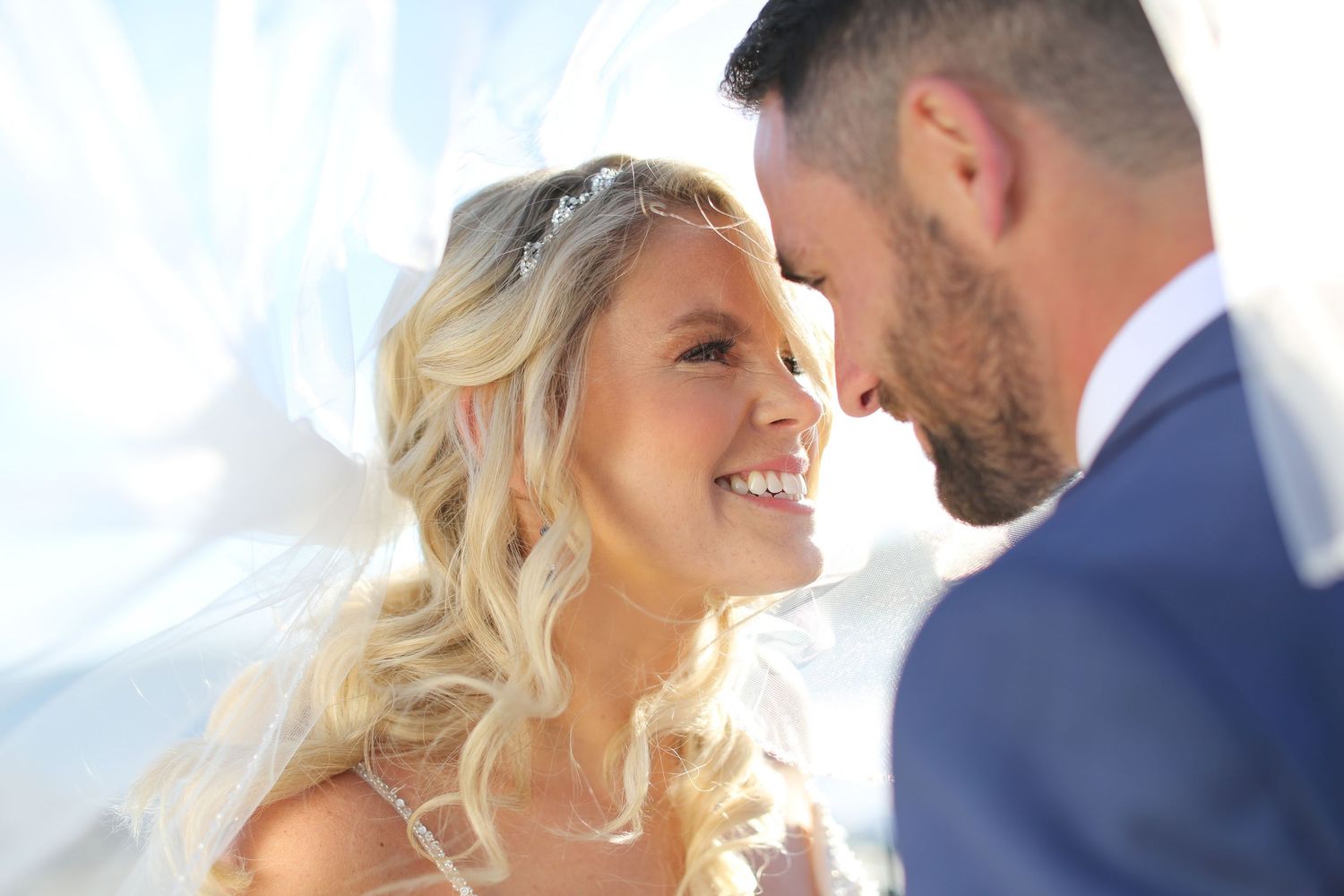 Close-up of romantic wedding couple moment in bright sunlight.