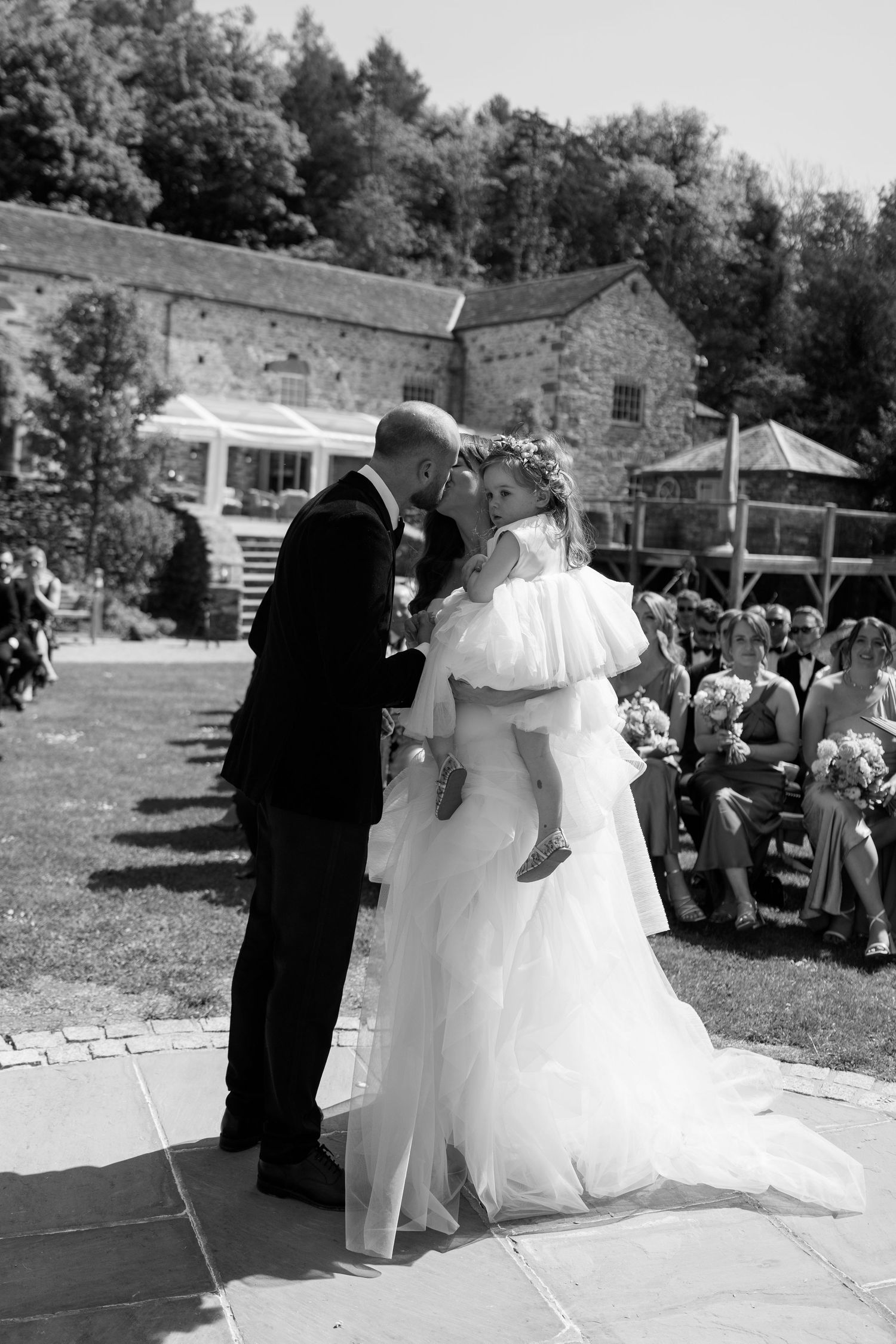 A wedding ceremony unfolds in a series of photos against a rustic stone building backdrop.