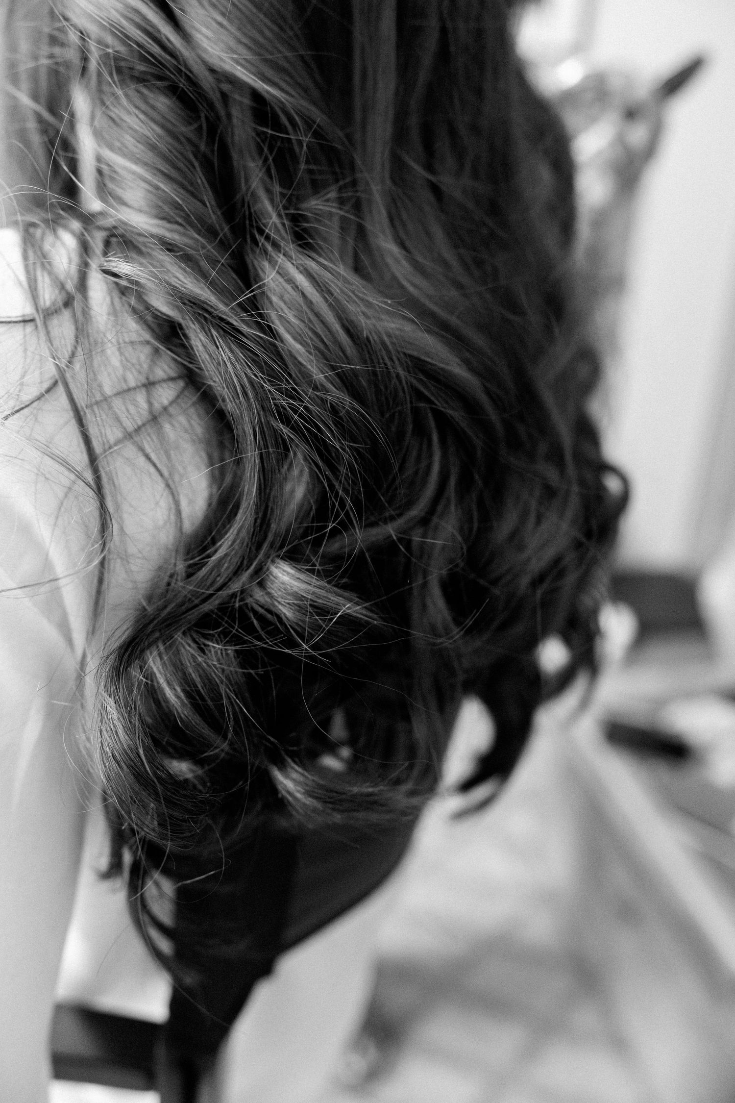Close-up sequence of wavy dark hair styling in black and white.