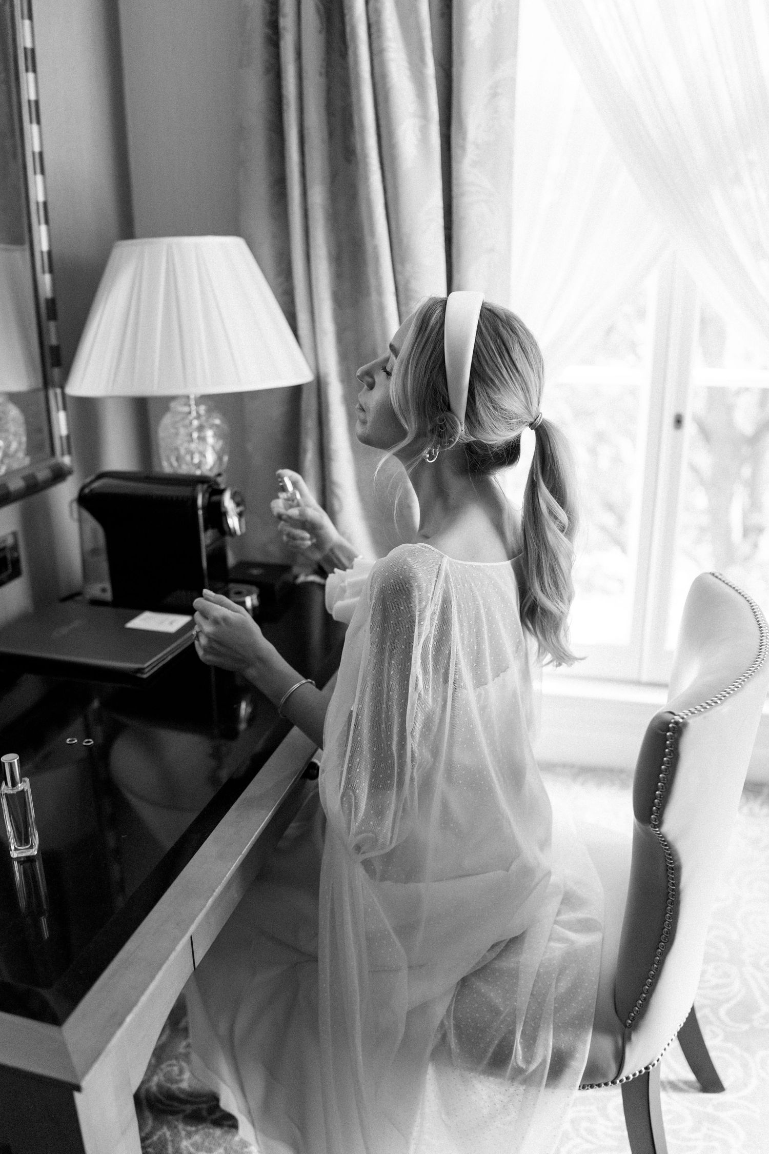 Ethereal bridal preparation sequence with white veil and window light.