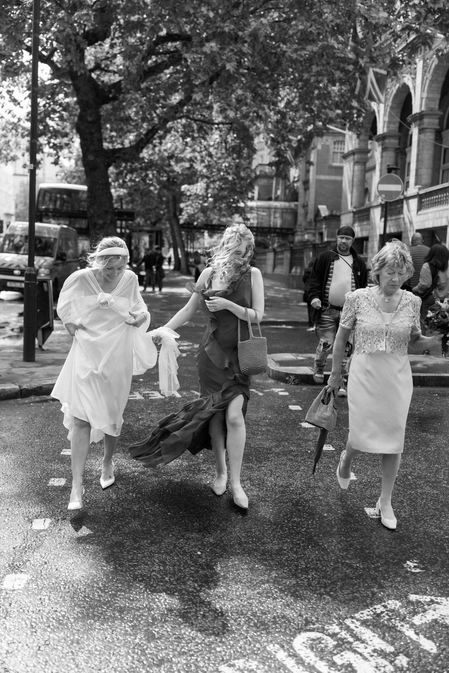 Black and white sequence showing playful movement across a grassy outdoor space in wedding attire.