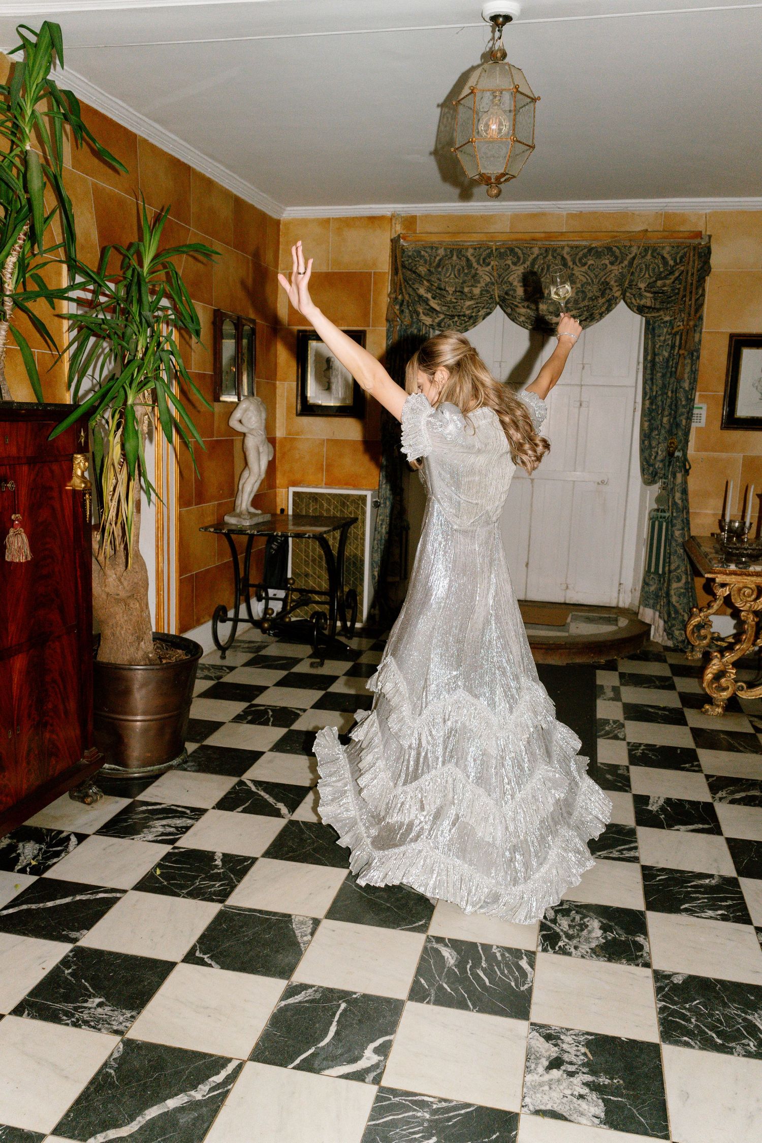 Dynamic dance poses captured in a room with dramatic lighting and checkerboard flooring.