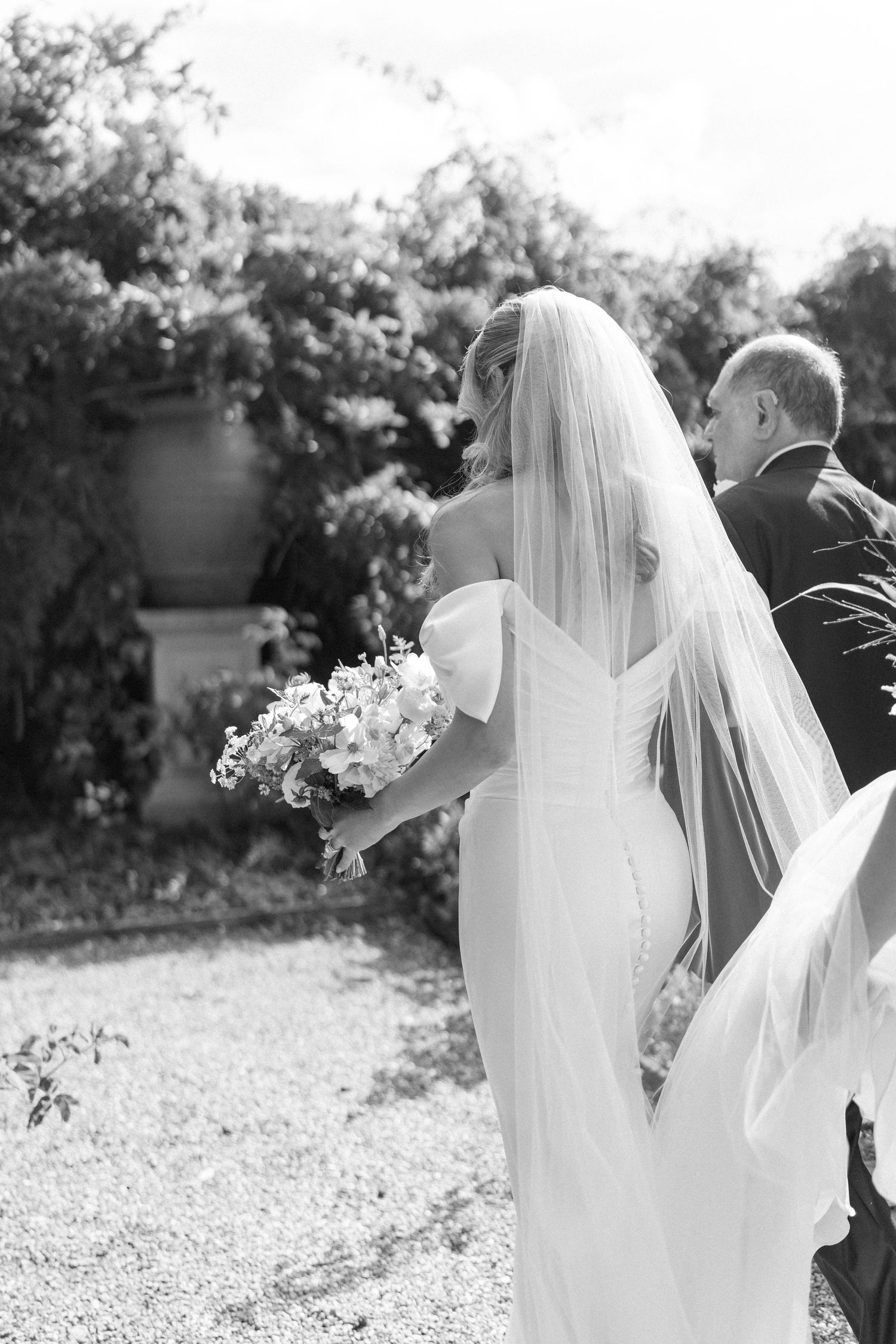Elegant wedding dress and veil details captured in black and white photography.